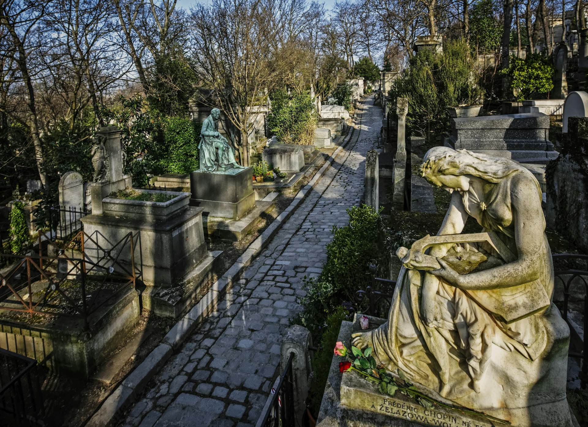 A white marble statue of an angel on the tomb of composer Frederic Chopin at Père-Lachaise Cemetery in Paris