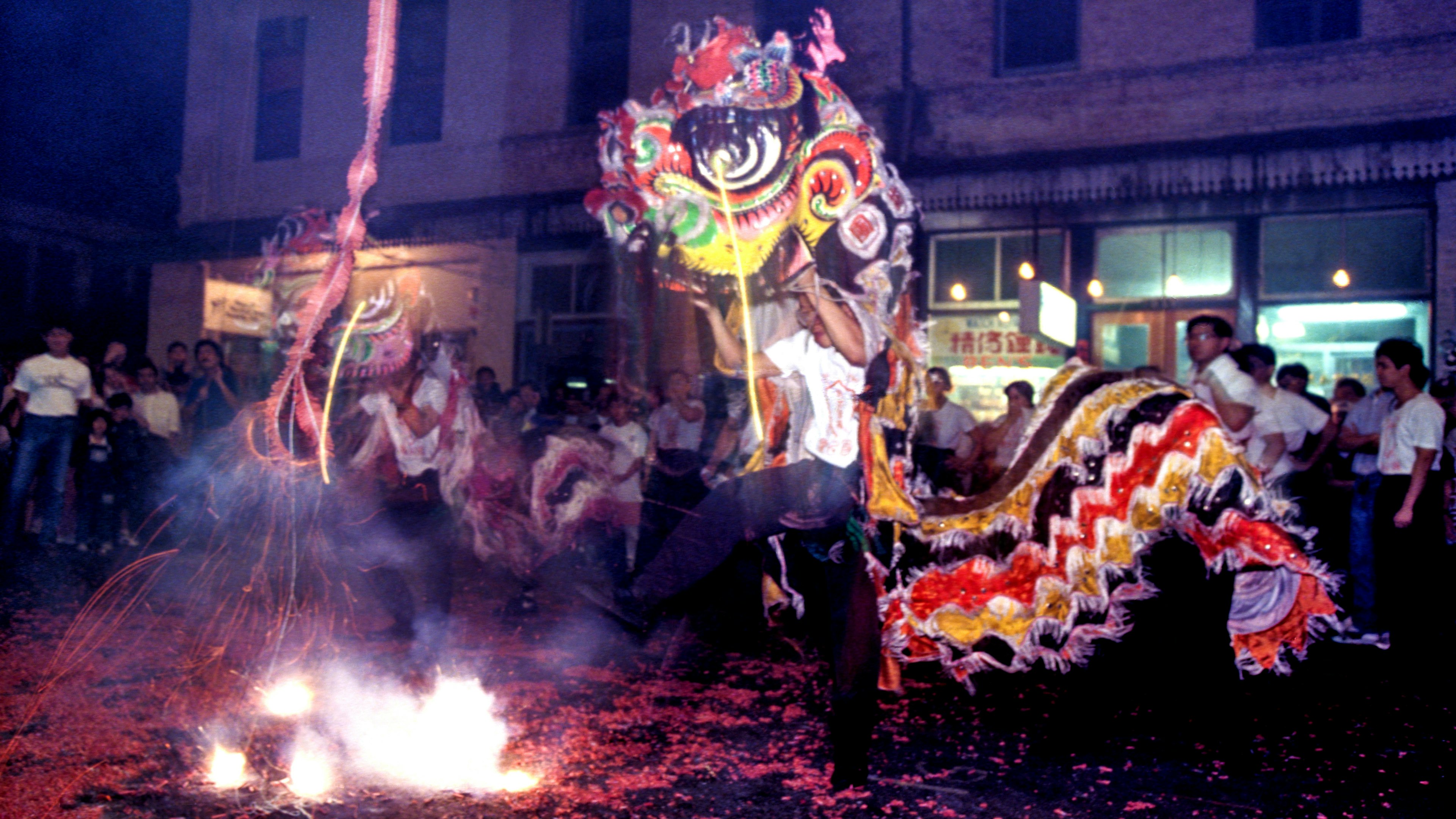 A man with a dragon costume dances at a New Year festival