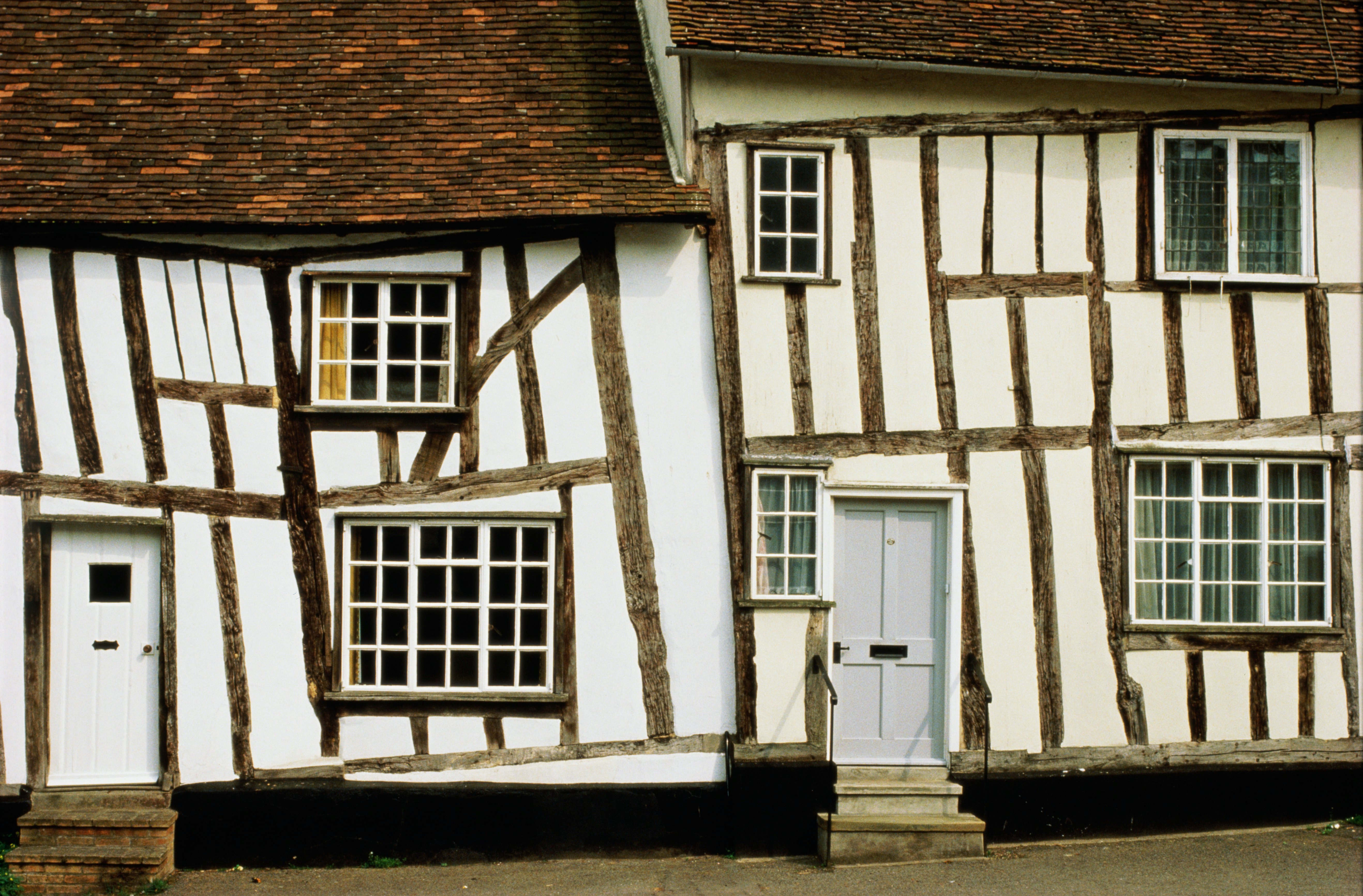 Two crooked timber-framed white houses in Levanham, England