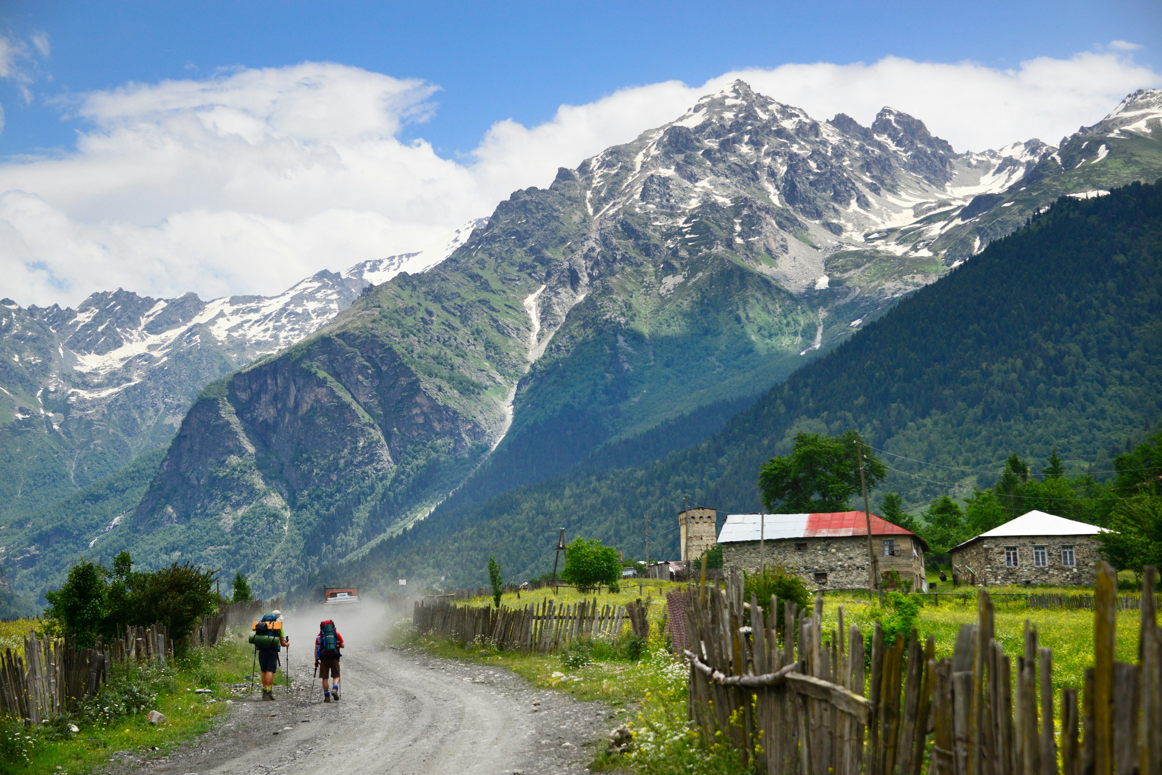 Two hikers following a path towards a mountain peak