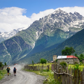 Hikers walking on dirt road at Cholashi village, Zemo Svaneti region, Caucasus mountain, Georgia.