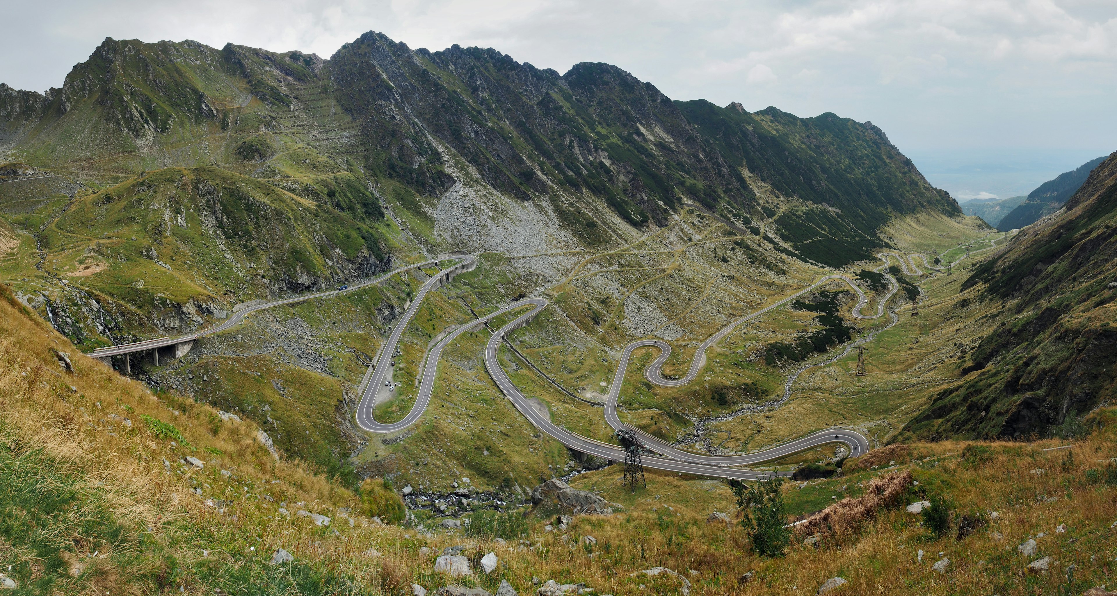 A winding mountainous road cross through the lush green hills.