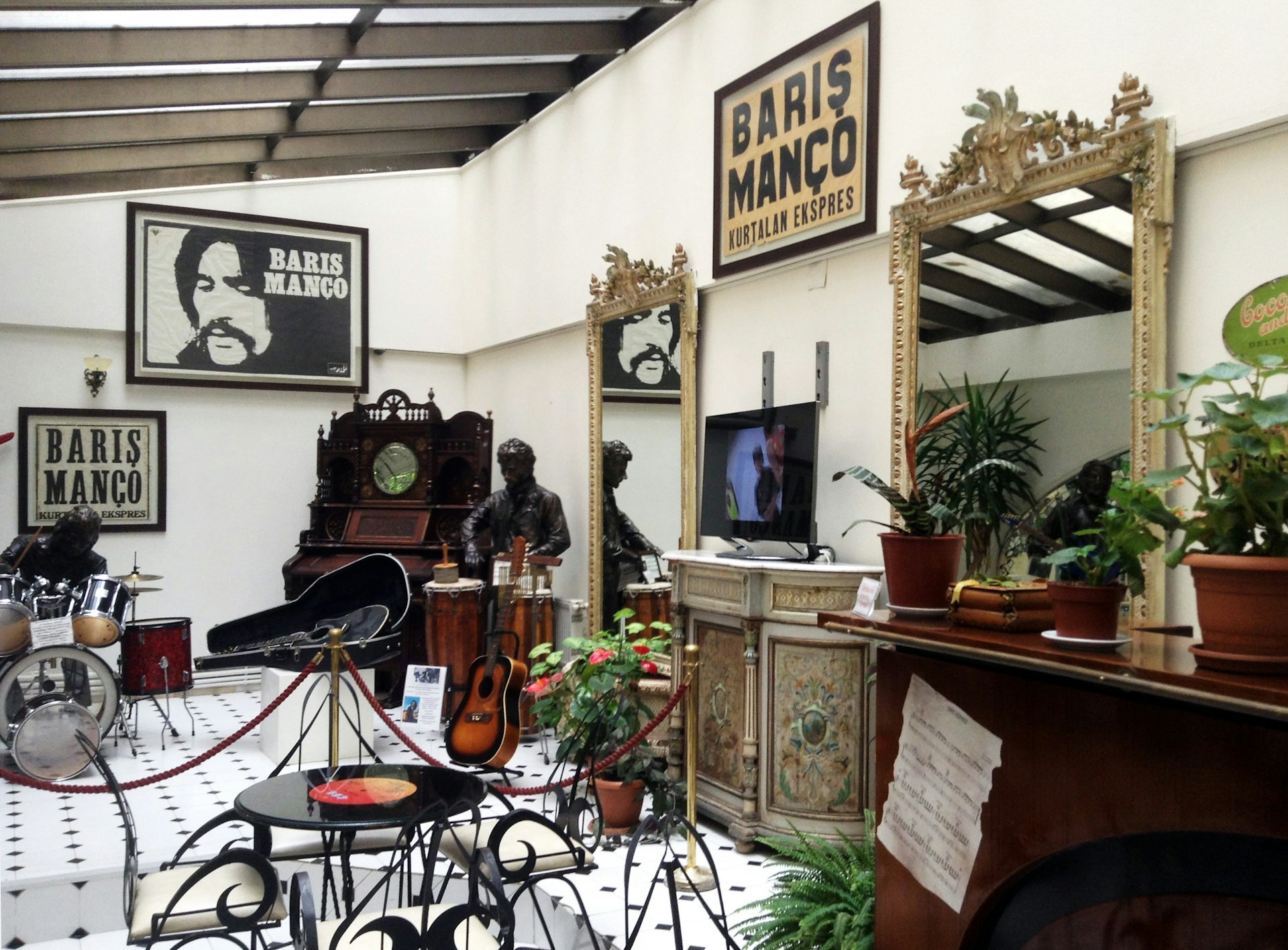 A room is laid out with instruments belonging to the Turkish rock star Barış Manço, and there are promotional posters hanging on the walls