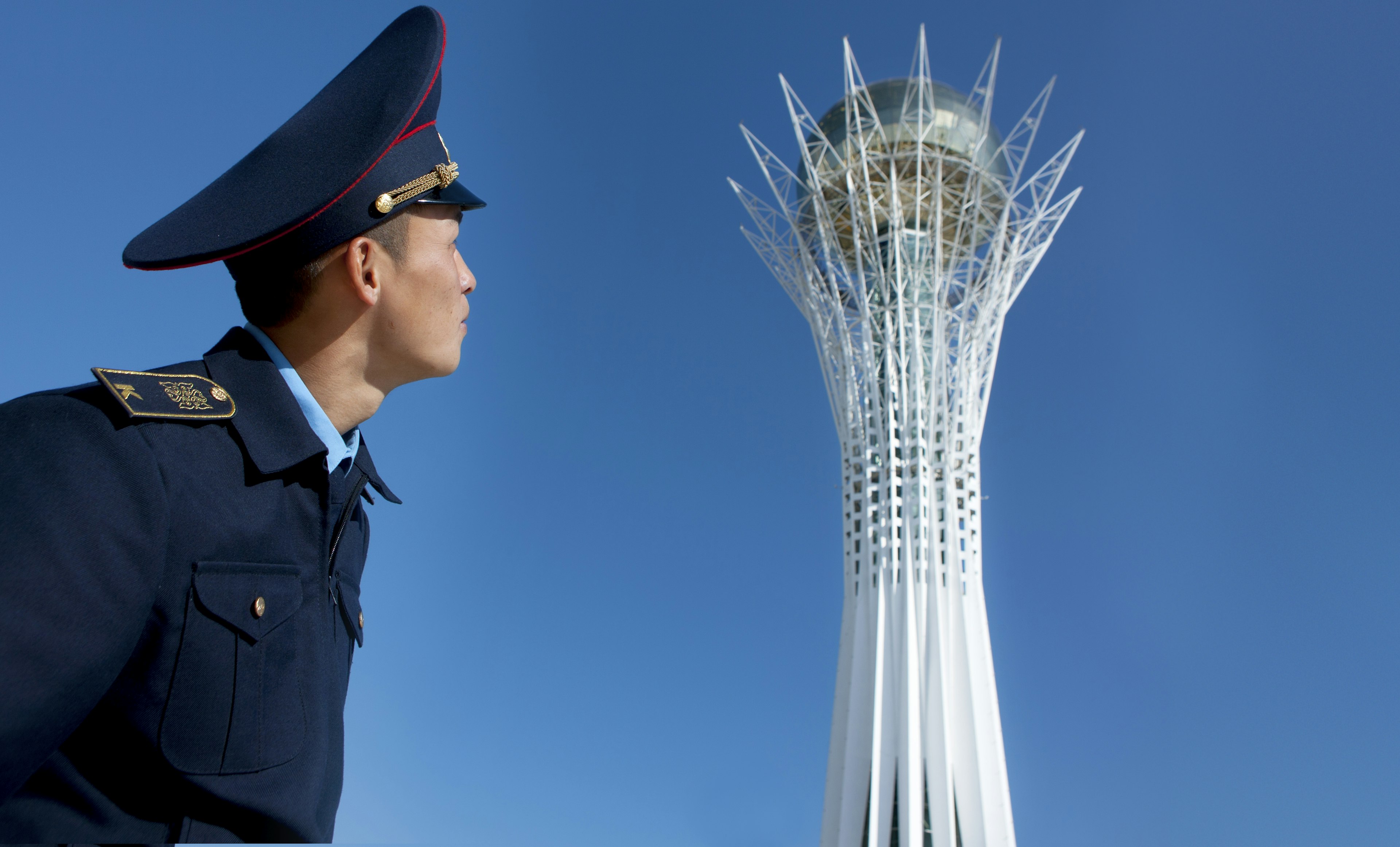 Military cadet looking up at Baiterek Tower, Astana, Kazakhstan