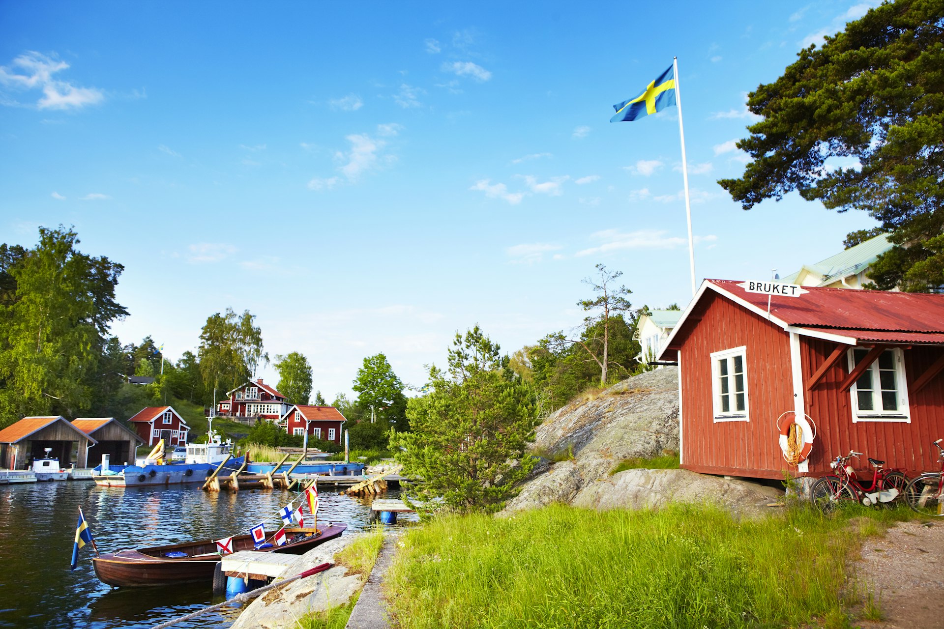 Boat houses on harbour in hamlet of Bruket, a lush part of the Stockholm peninsula. 