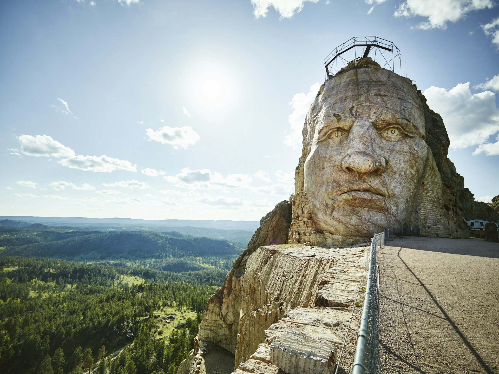 A huge stone sculpture of a head and face on a hill