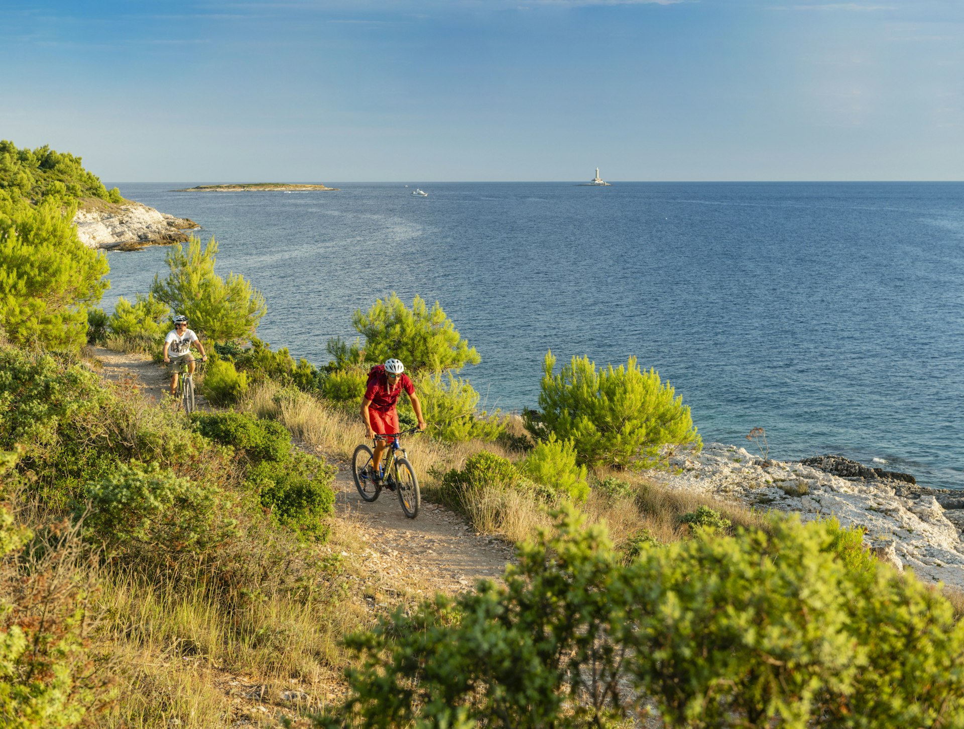 Cyclists on trails at Cape Kamenjak, which follows the rocky coastline.
