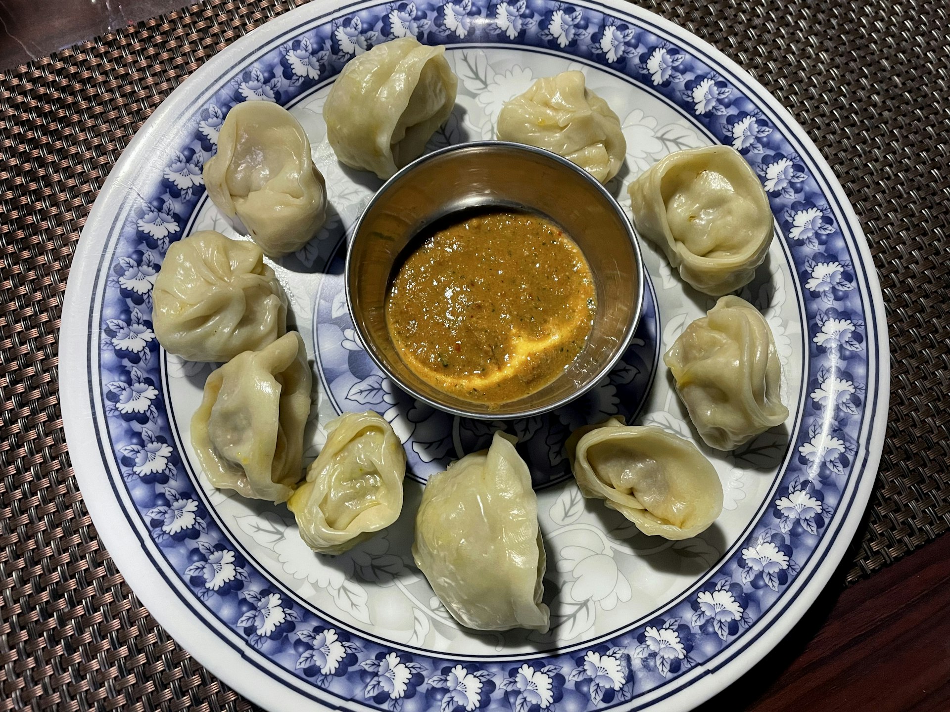A dish with small white dumplings surrounding a bowl of dip