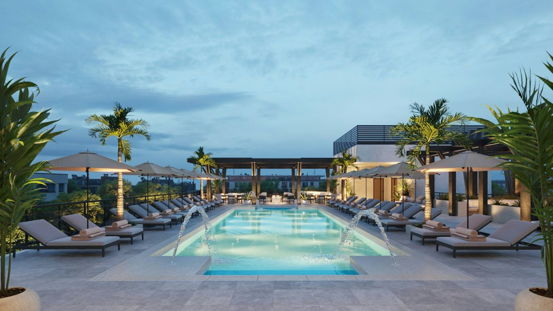 Sunloungers are arranged around a stylish rooftop pool, which is illuminated with pale blue lights