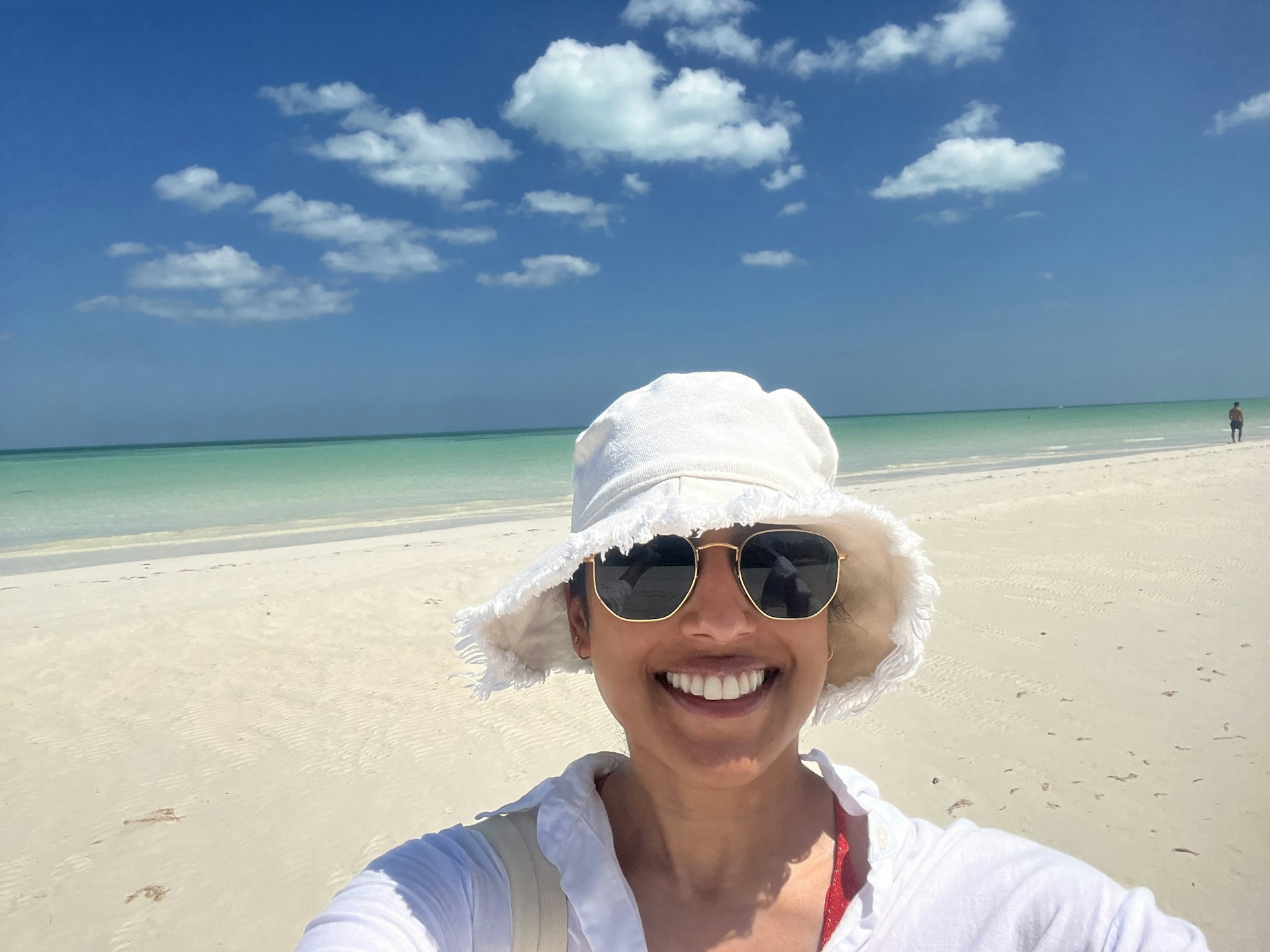 The author in a sun hat on a sunny beach