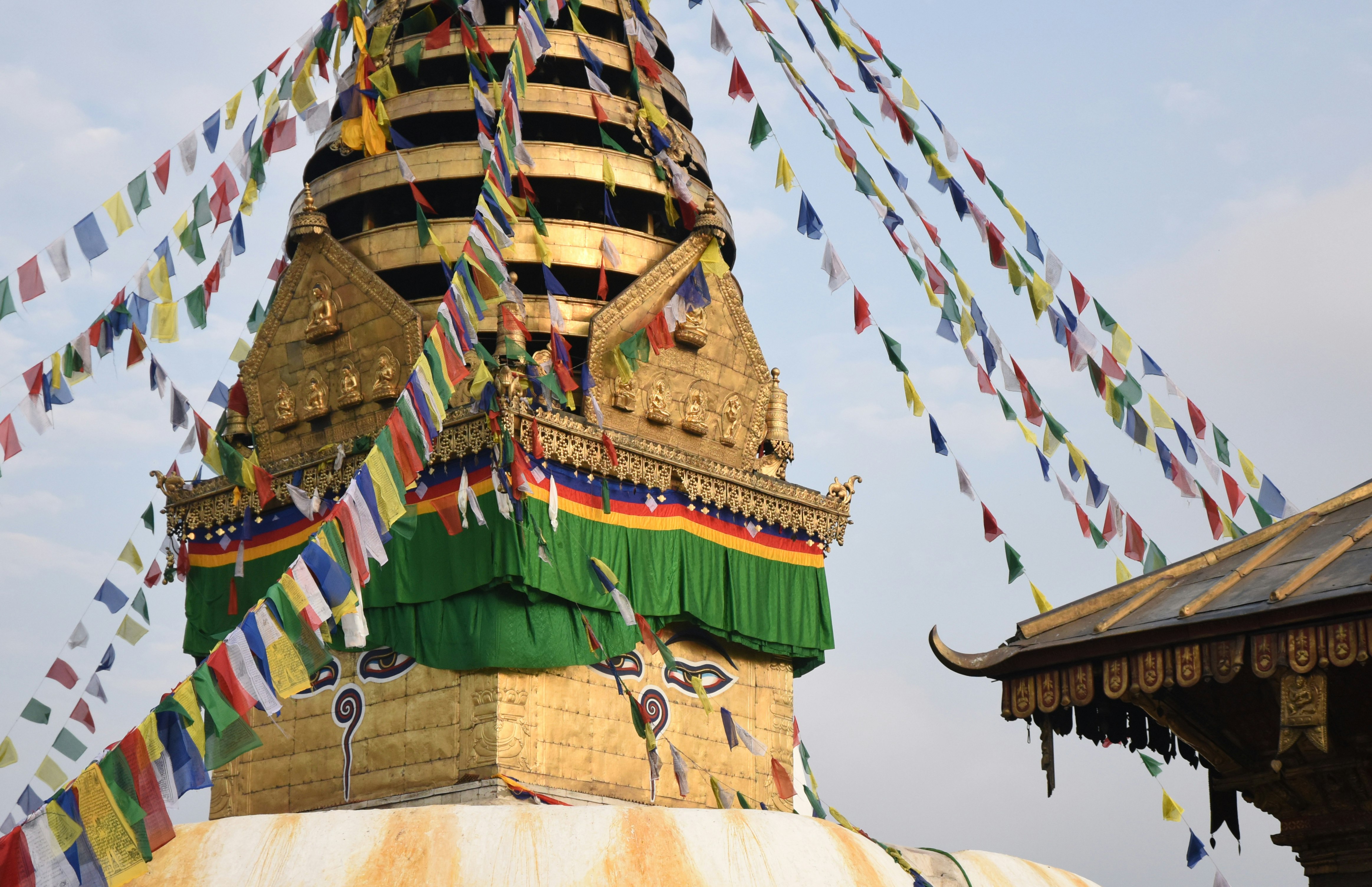 A gold stupa adorned with colorful prayer flags