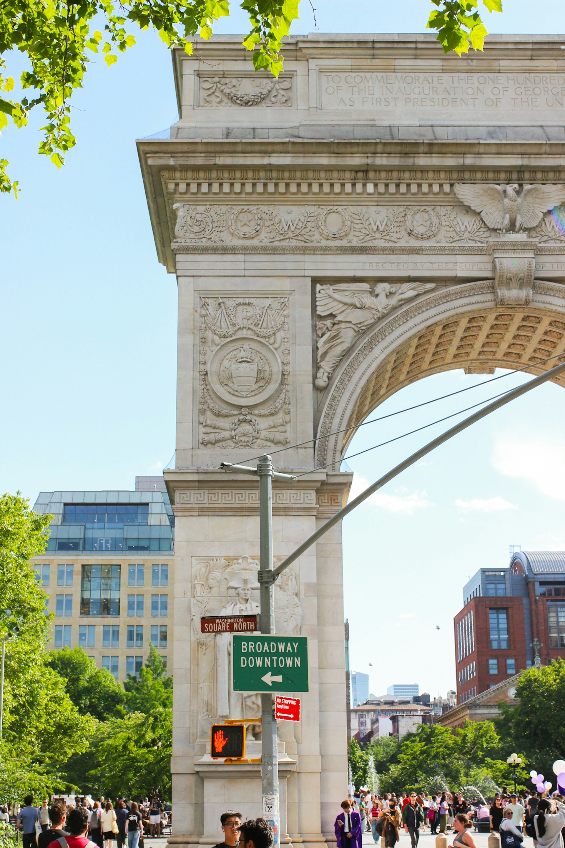 A large white stone arch and a street sign saying Washington Square North
