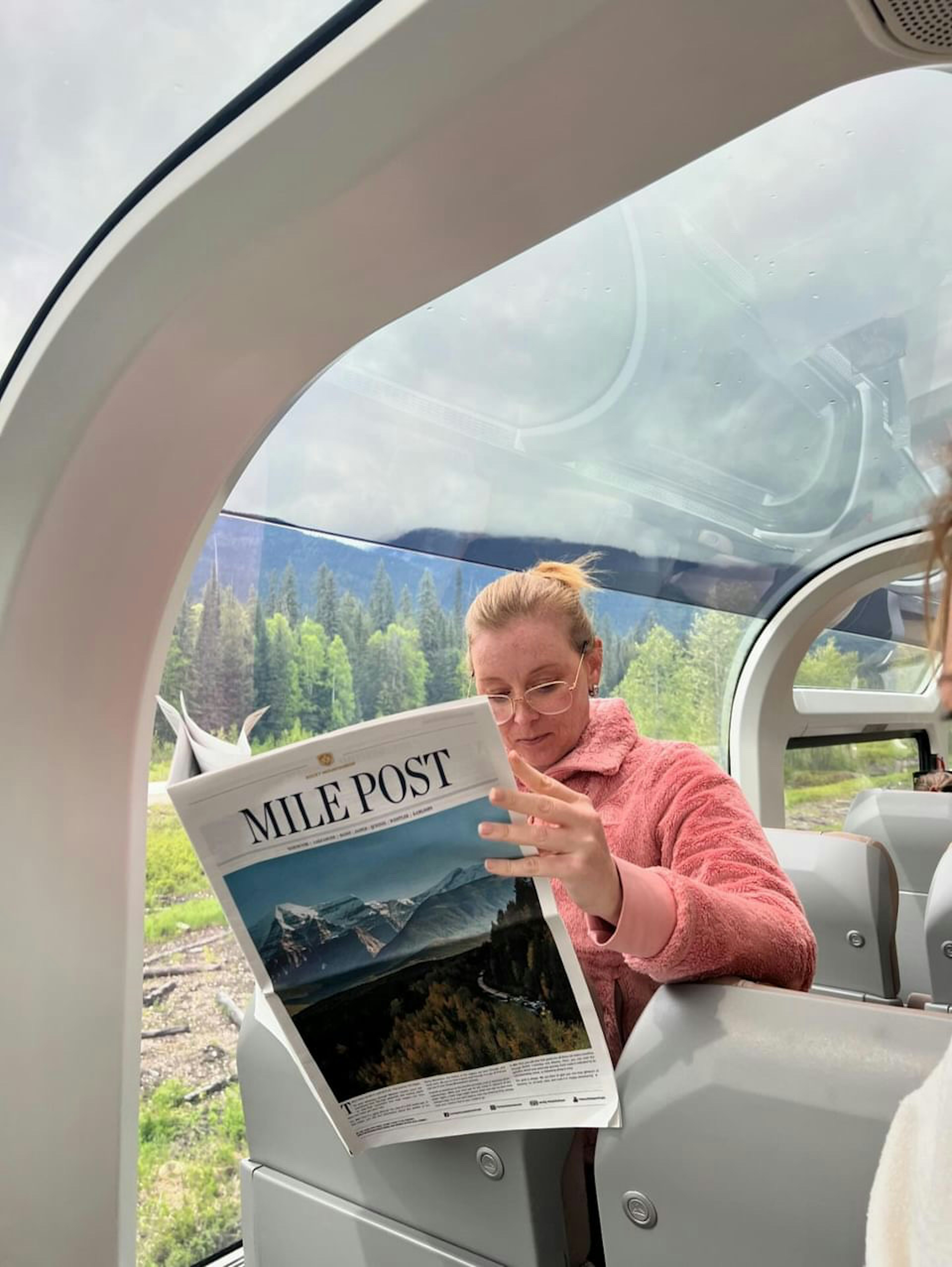 Lonely Planet editor Melissa Yeager reading the newspaper outlining the approaching scenic points. 