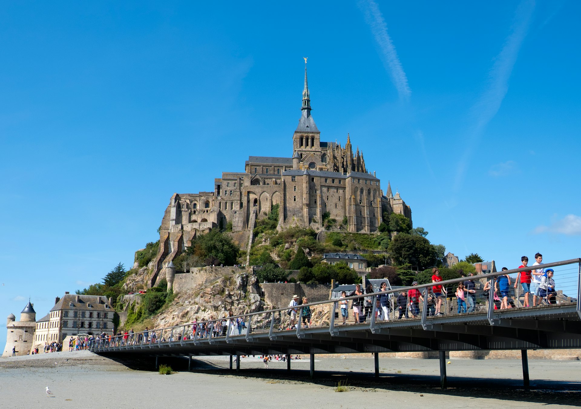 People on a walkway across the bay approaching Mont St-Michel, Normandy, France