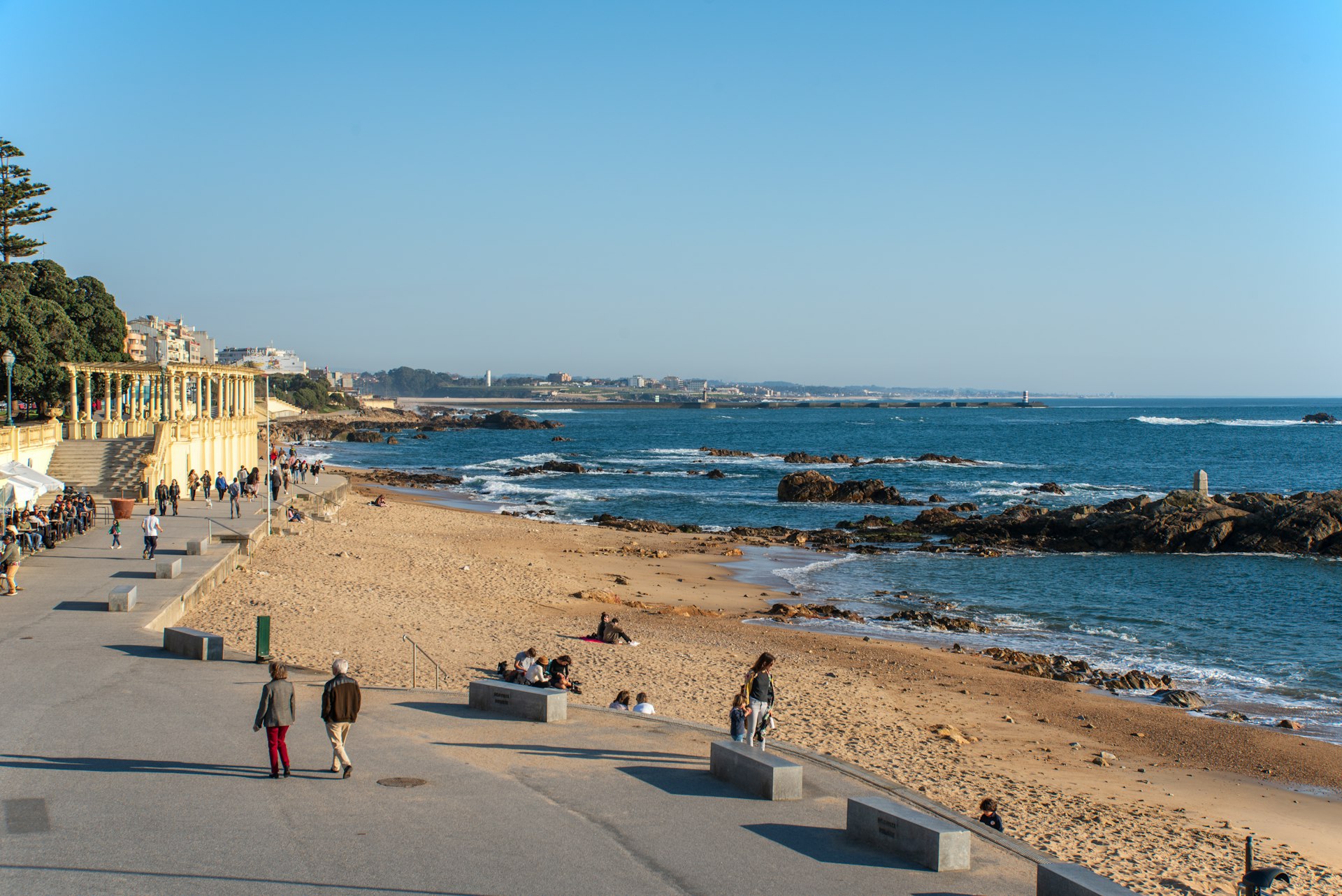 People walk along a beachfront path by the Atlantic Ocean, Porto, Portugal