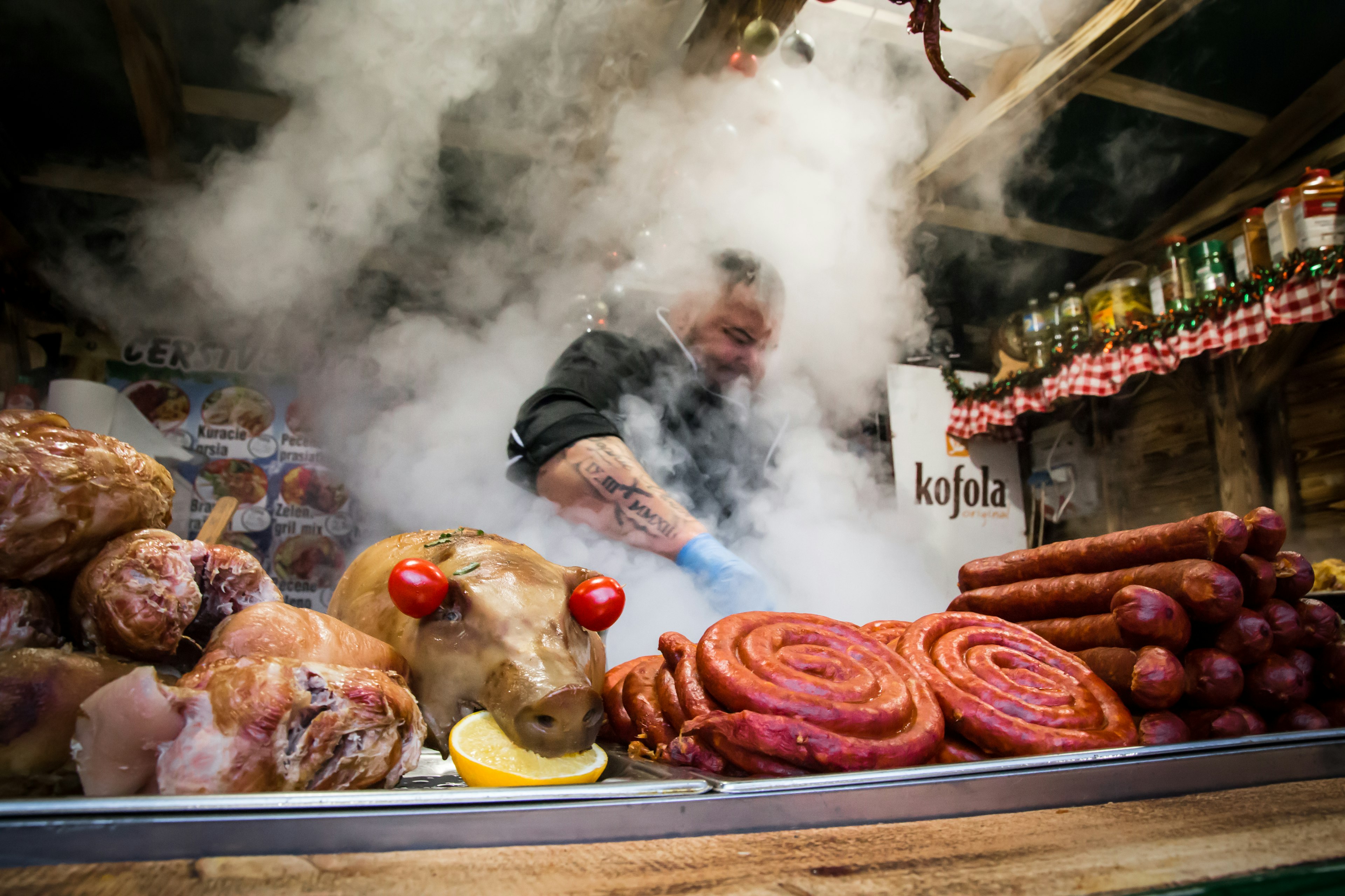 A man grills meats at a food stall at a Christmas market in Hviezdoslavovo námestie, Old Town, Bratislava, Slovakia