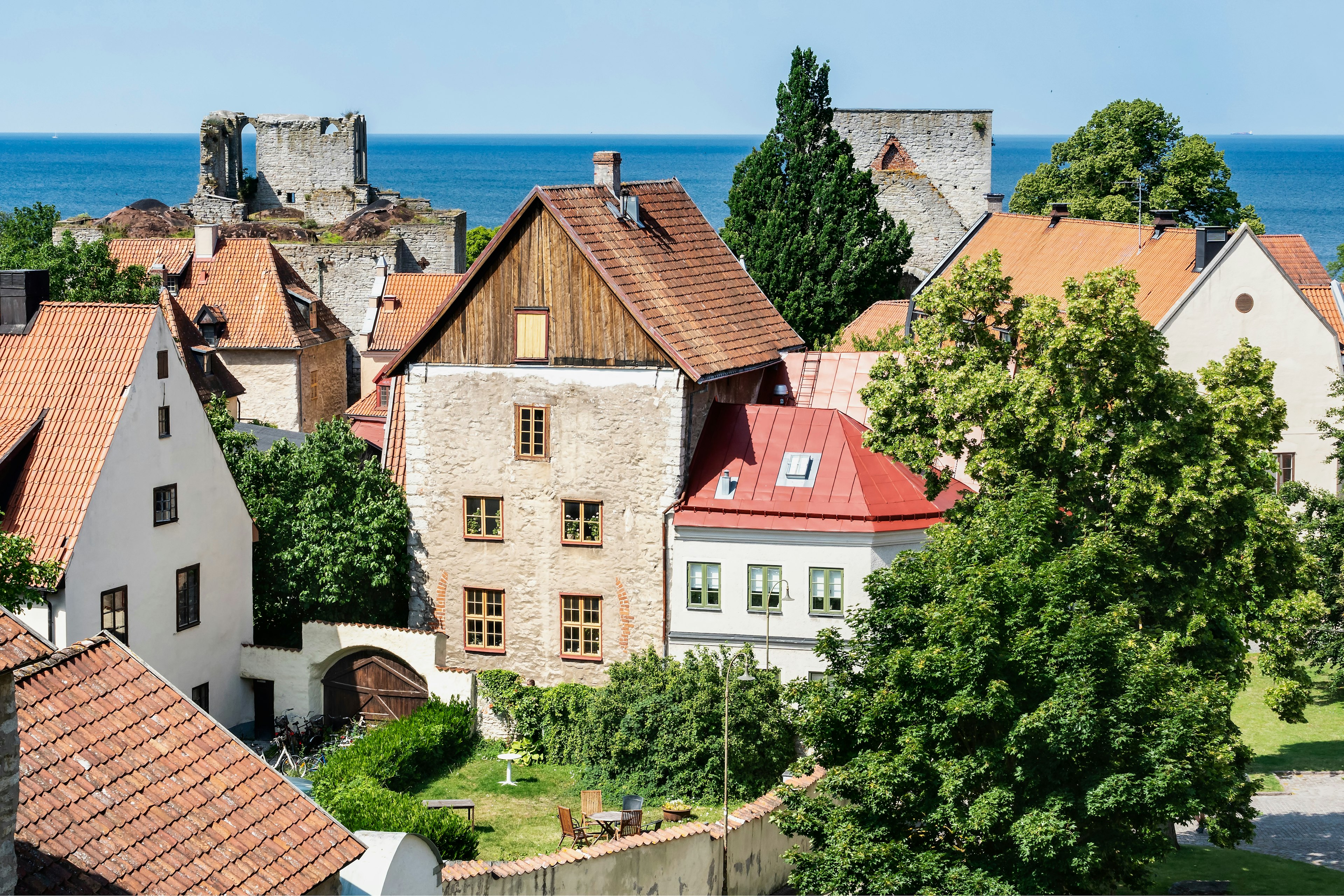 View over the old town of the city of Visby with ancient buildings and the sea in the background.