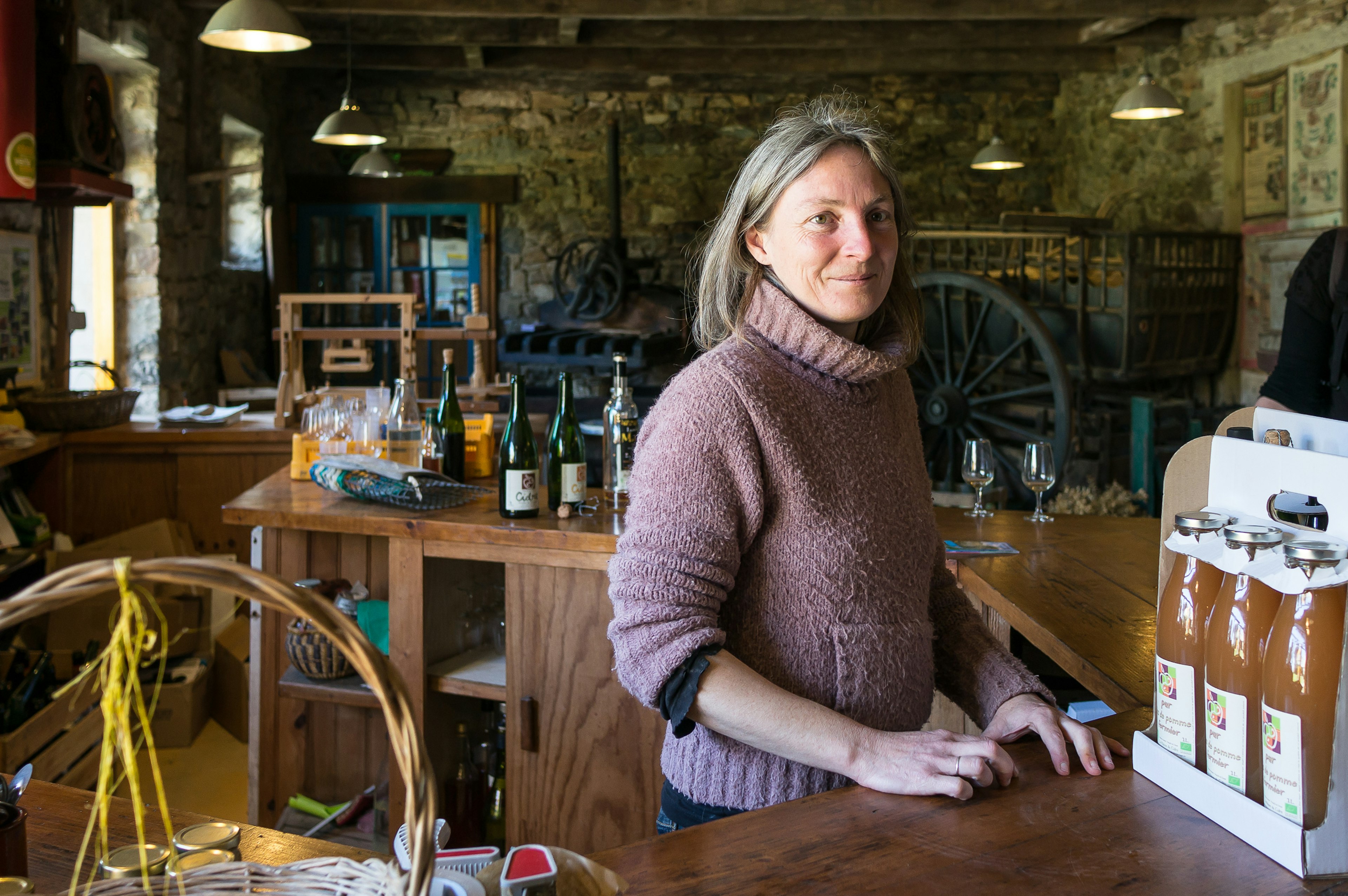 Woman sells apple juice, cider, pommeau and calvados in Argol, Brittany, France