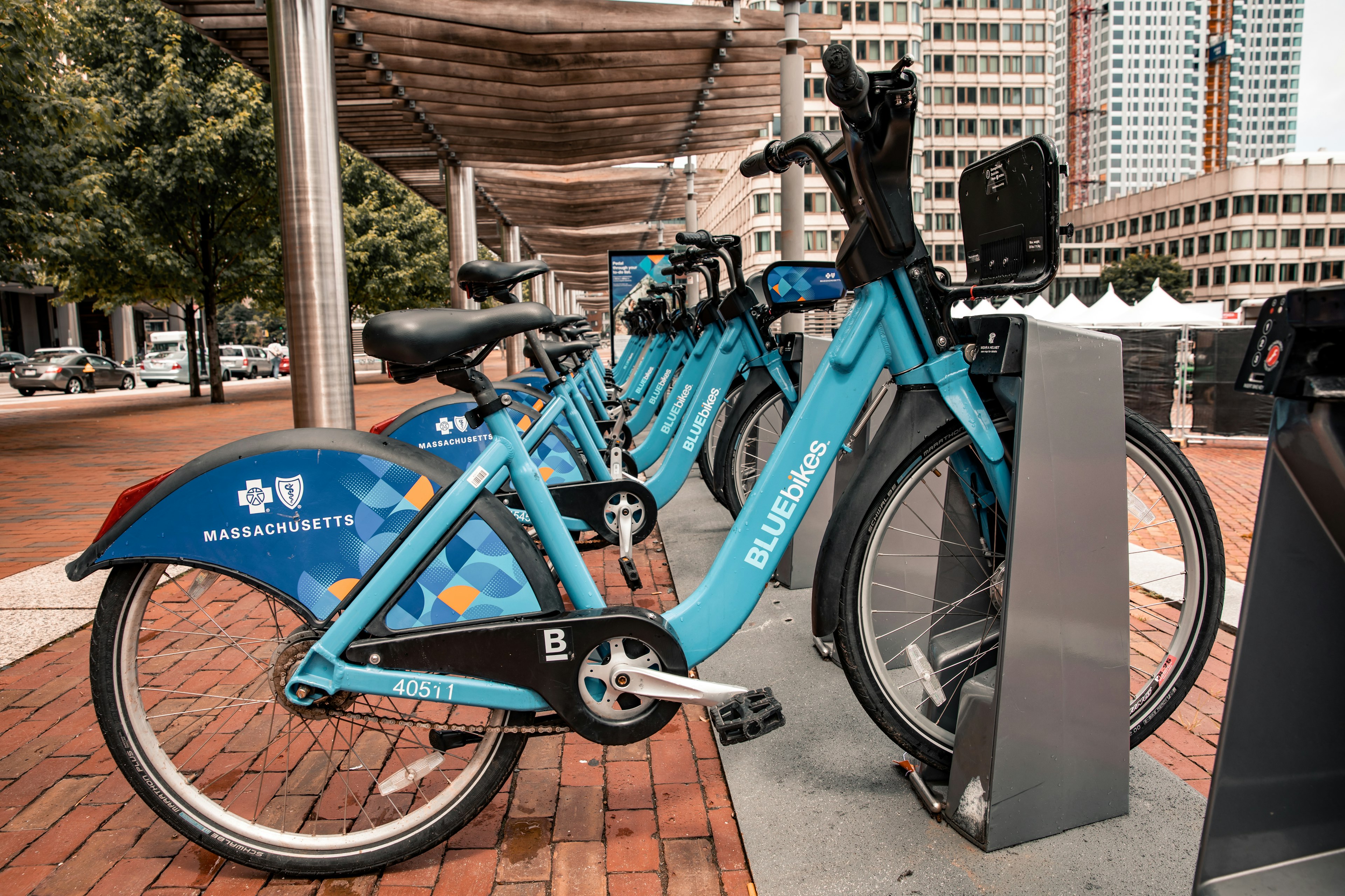 A row of identical blue bikes available for hire from street stations