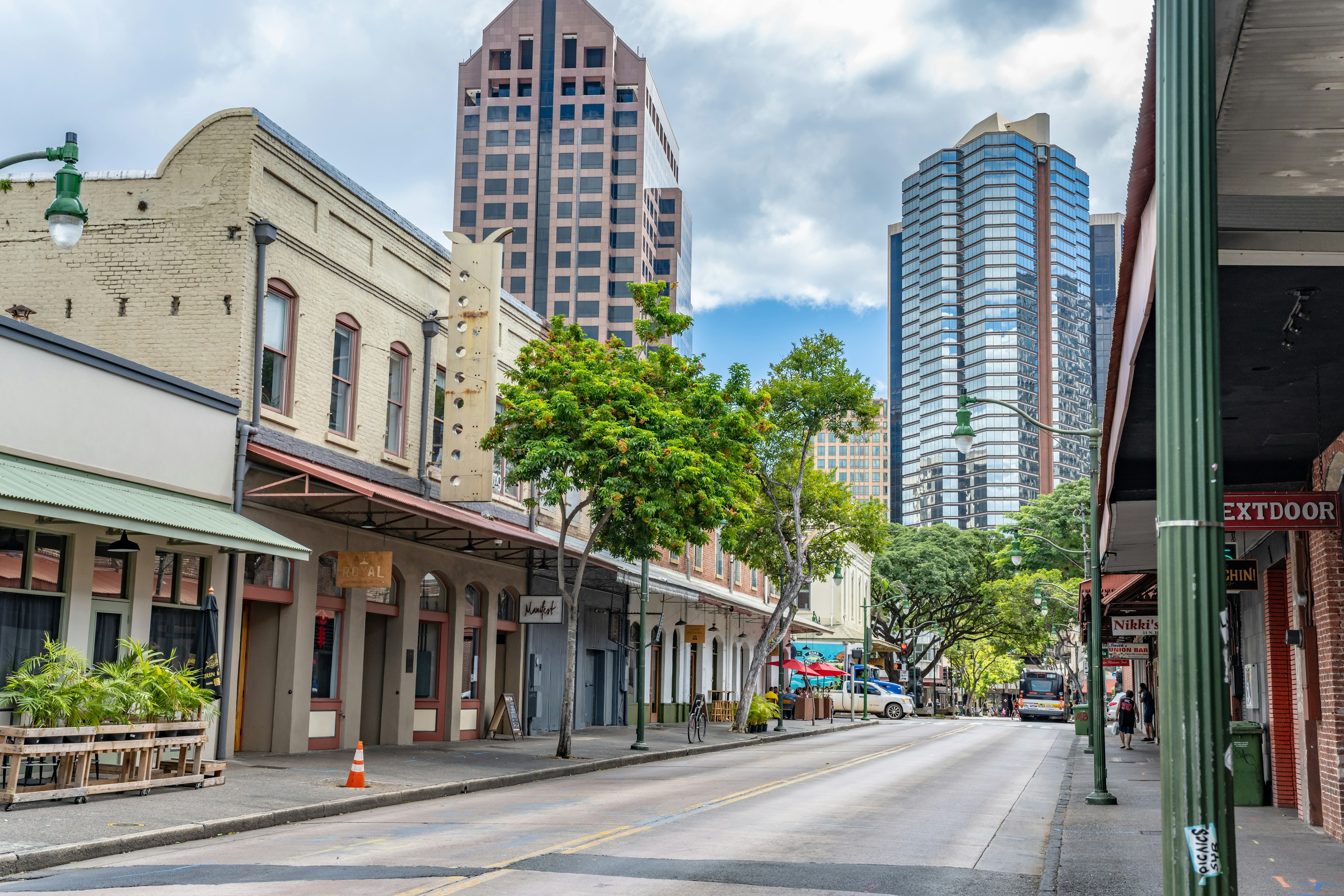 A street with historic low-rise buildings and taller glass and steel modern creations in the distance