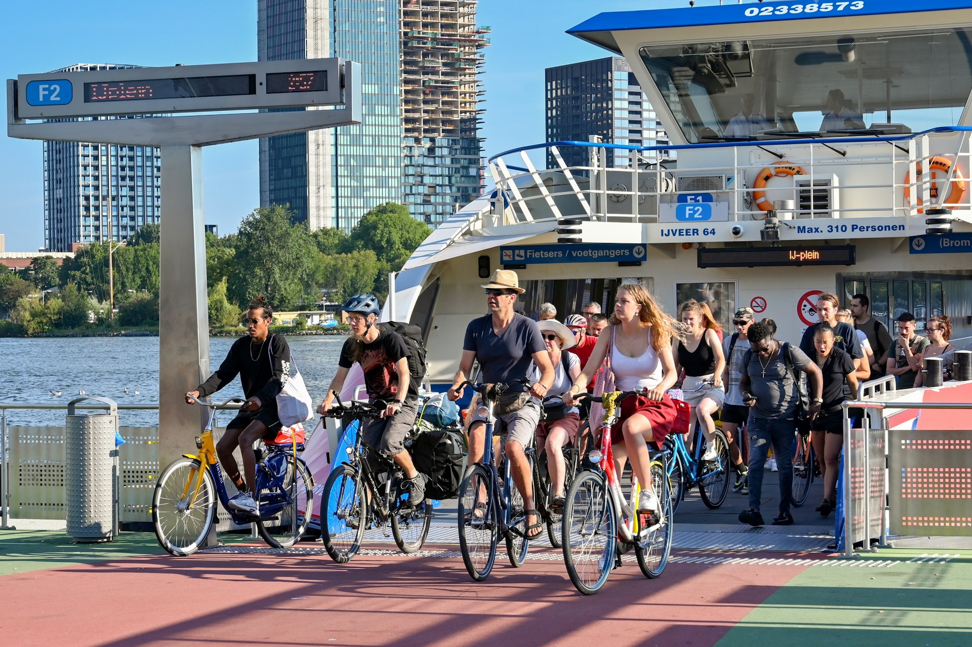 People on bicycles riding off a shuttle ferry service on the waterfront in Amsterdam