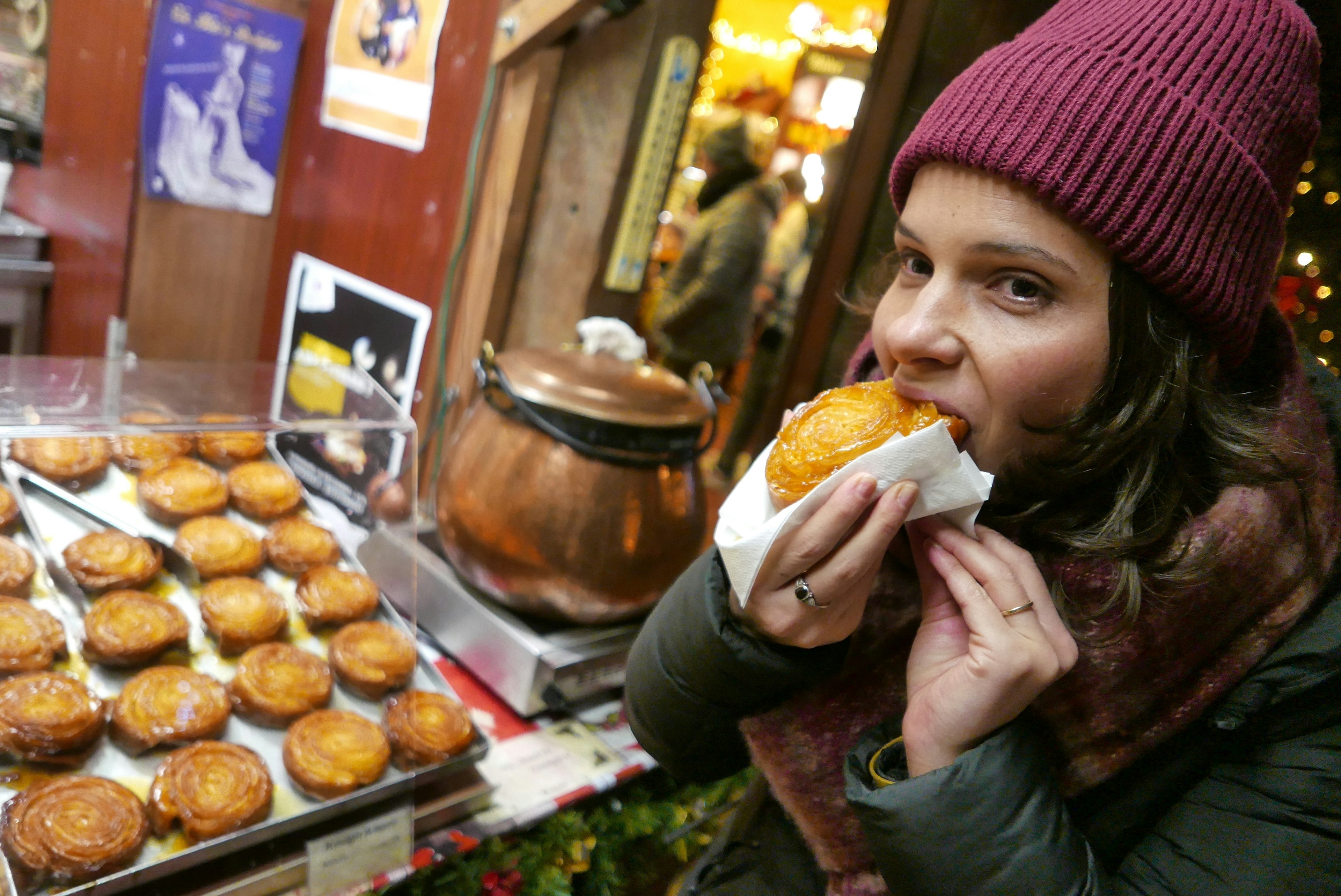 woman eats a kouign amann, a dessert typical of Brittany, in Rochefort-en-Terre, Brittany, France