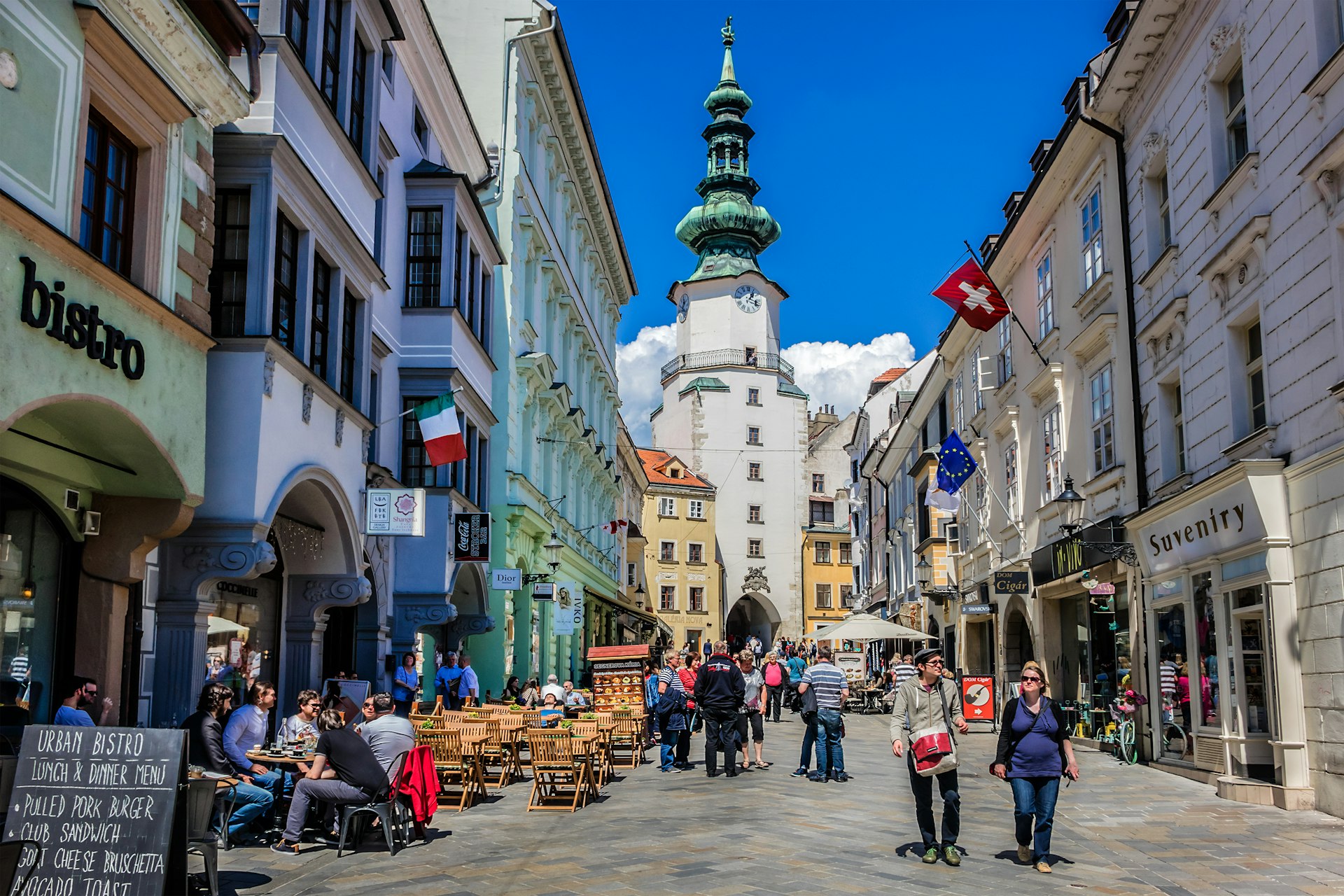People walk down a street in the Old Town of Bratislava, Slovakia