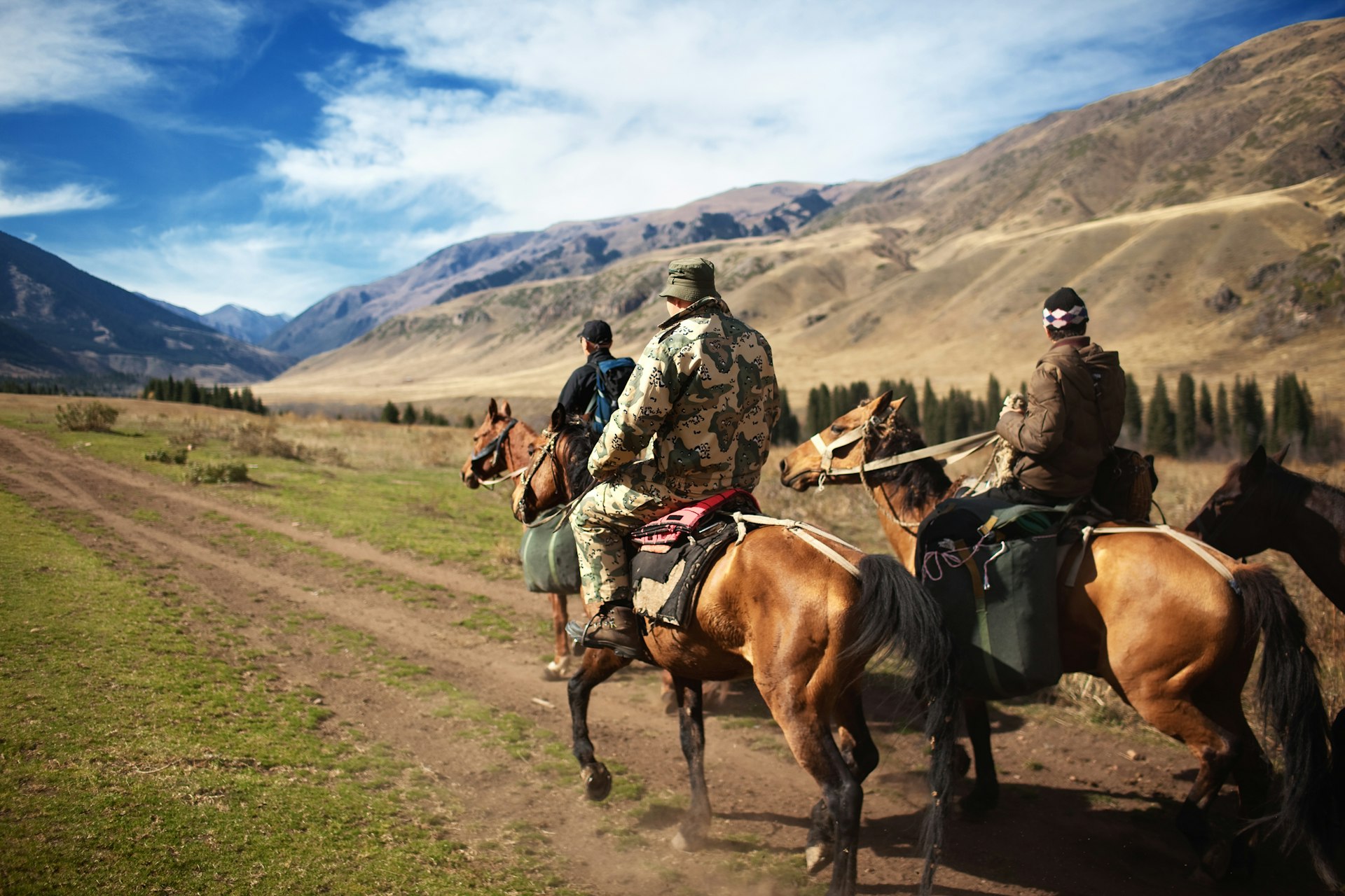 Men on horseback riding in the mountains of Kazakhstan