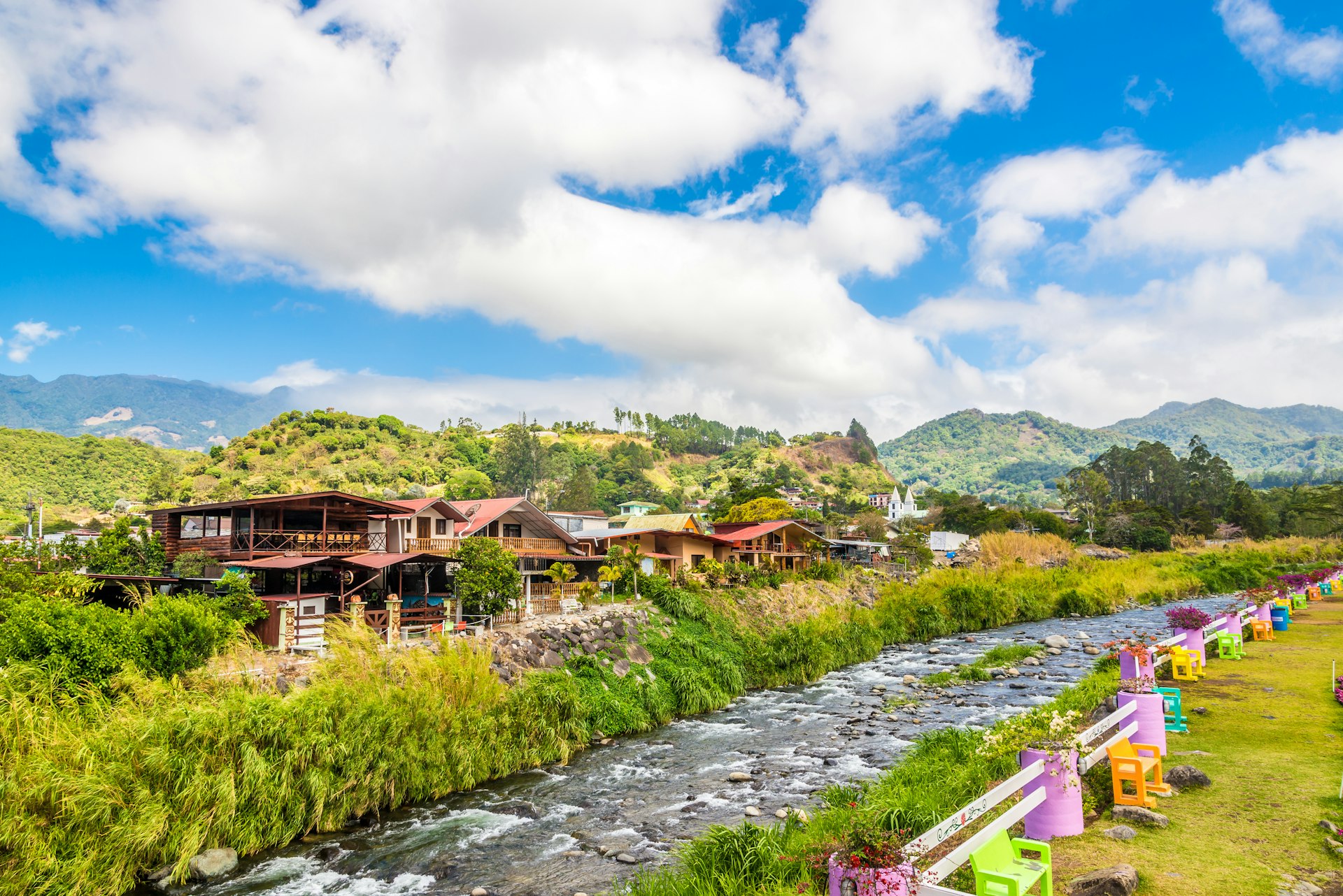 A river runs at the edge of a town in a rural area