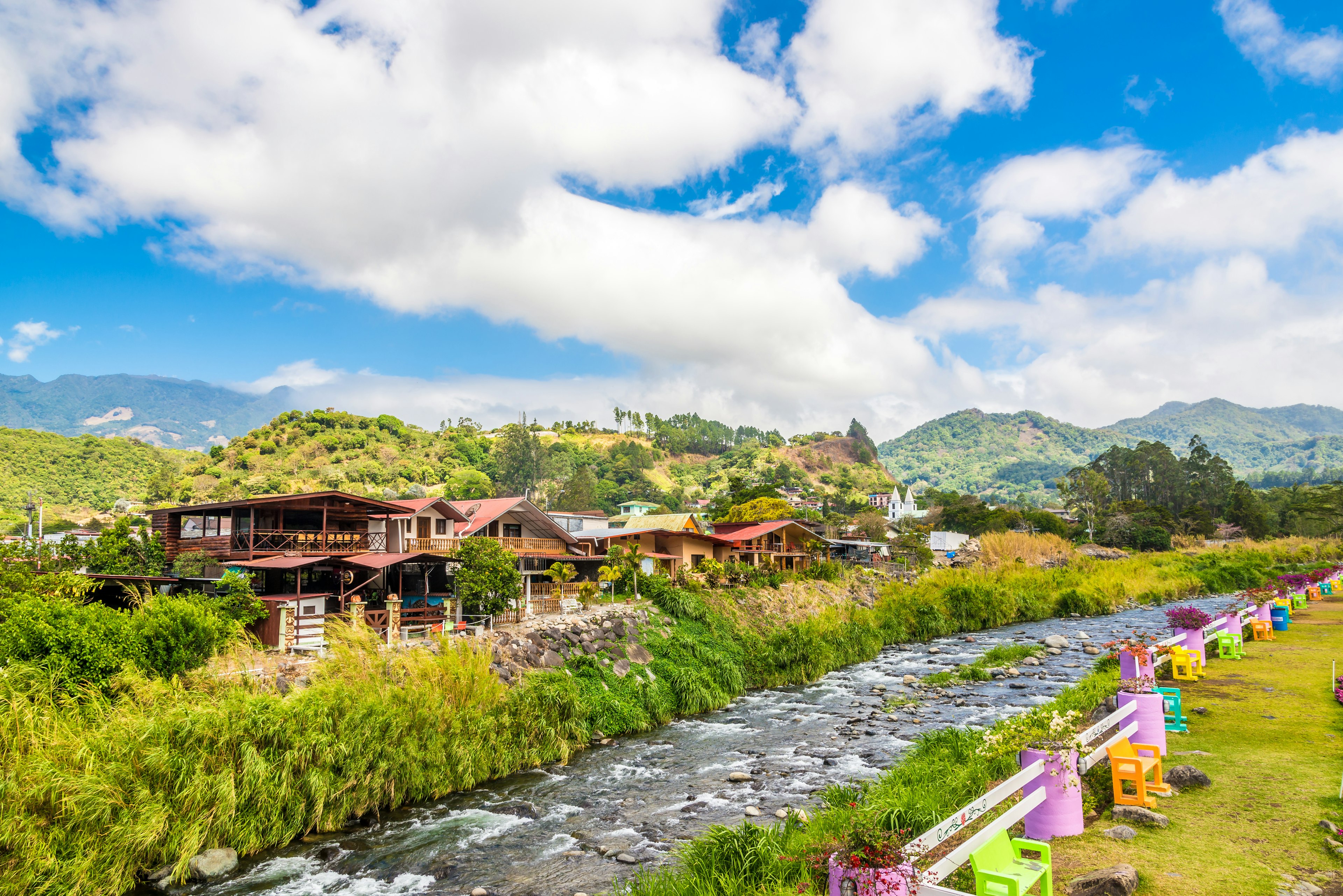 A river runs at the edge of a town in a rural area