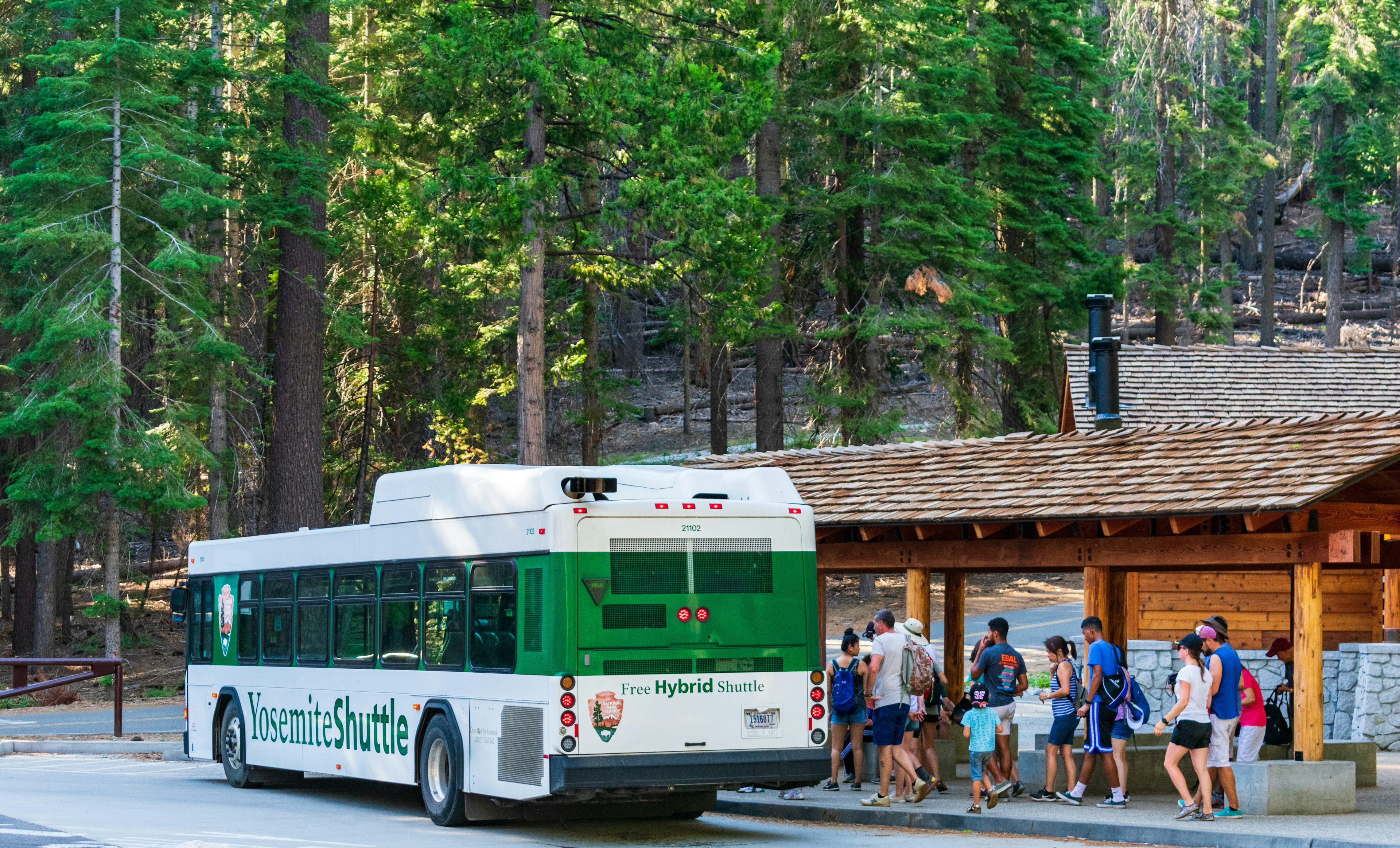 Tourists board a free Yosemite shuttle service bus at Yosemite Valley.