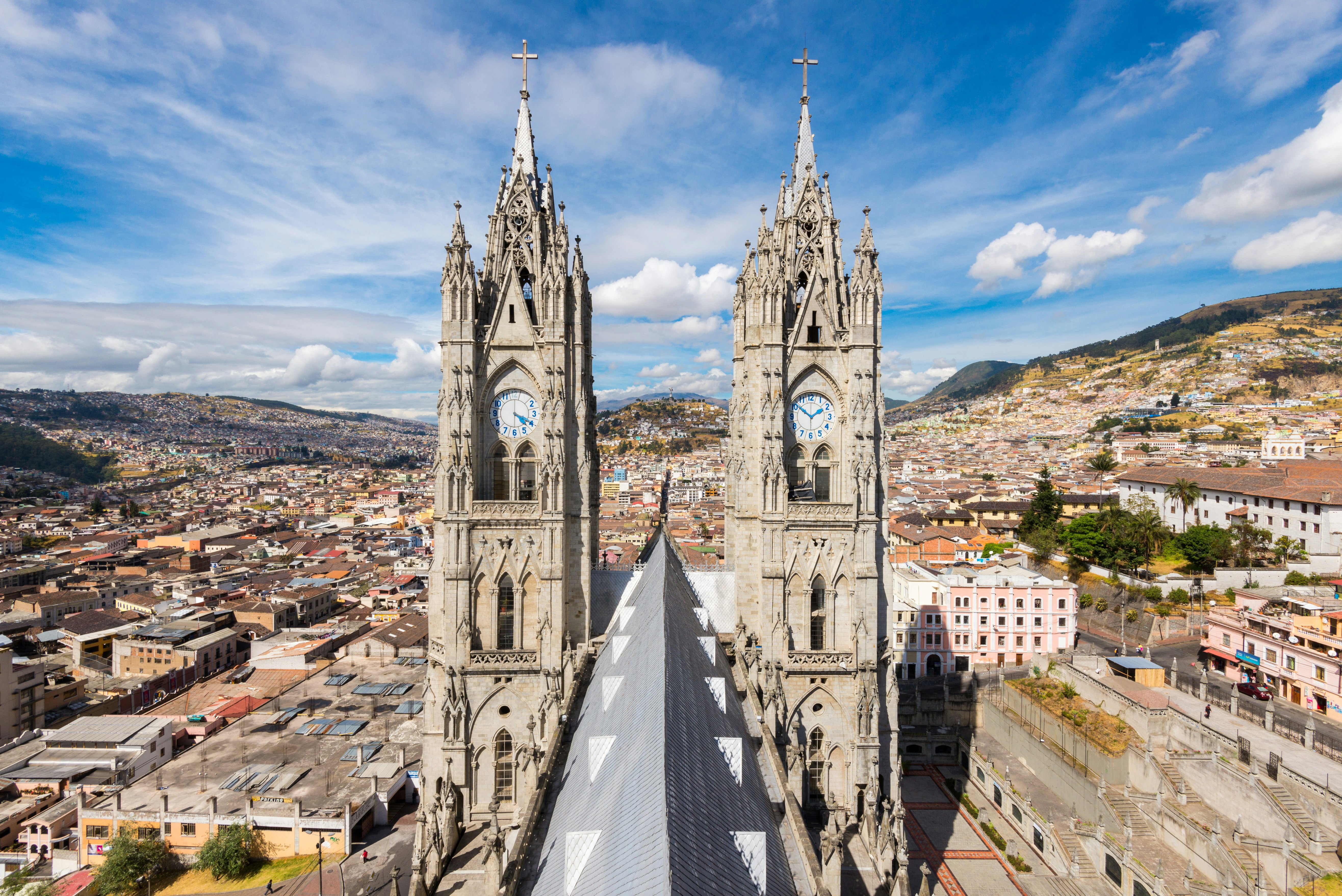 Twin-spires of a cathedral loom over a hilly city