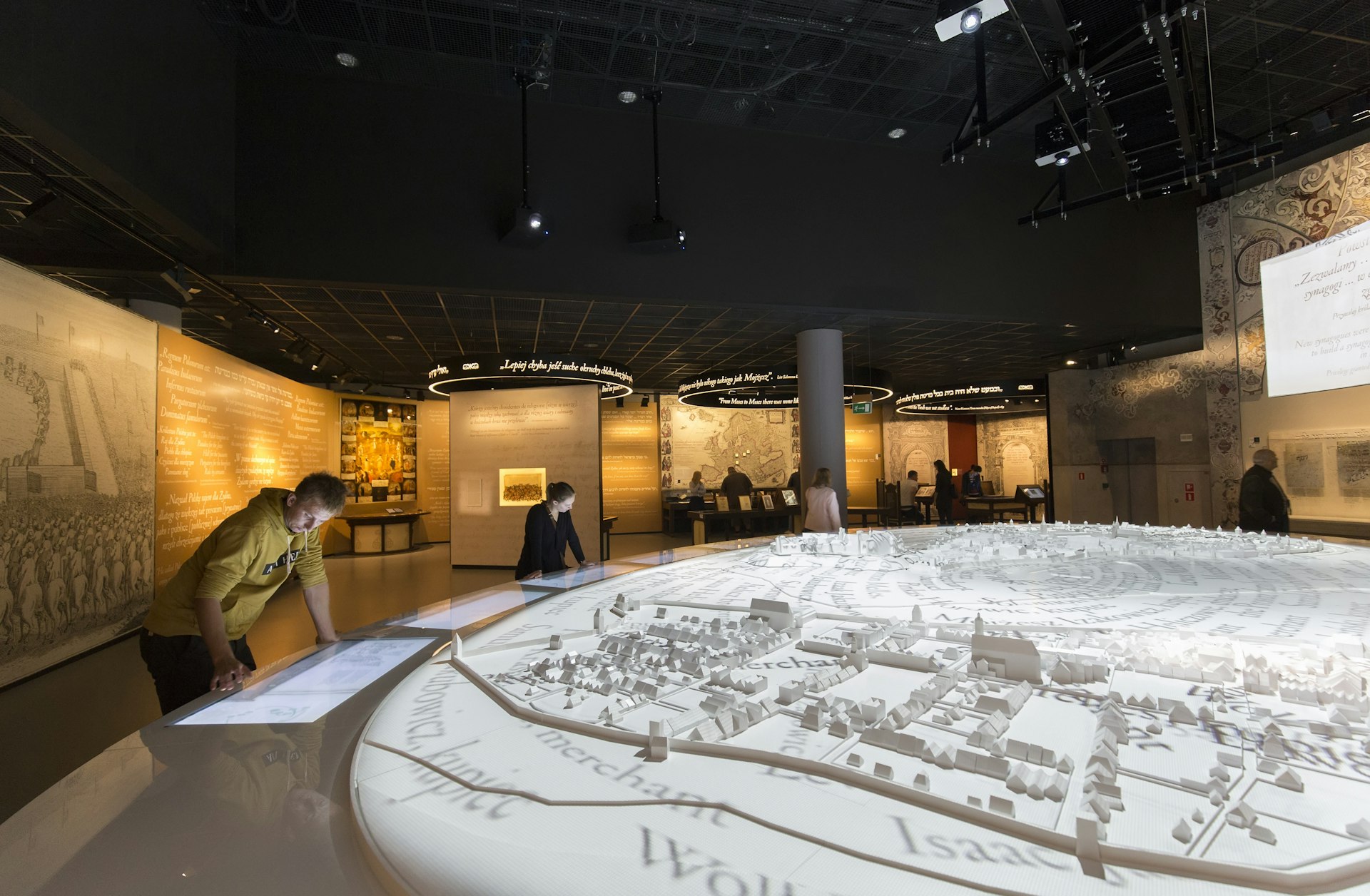Muitas pessoas estão olhando as exposições interativas dentro do Museu de História dos Judeus Poloneses (POLIN) 