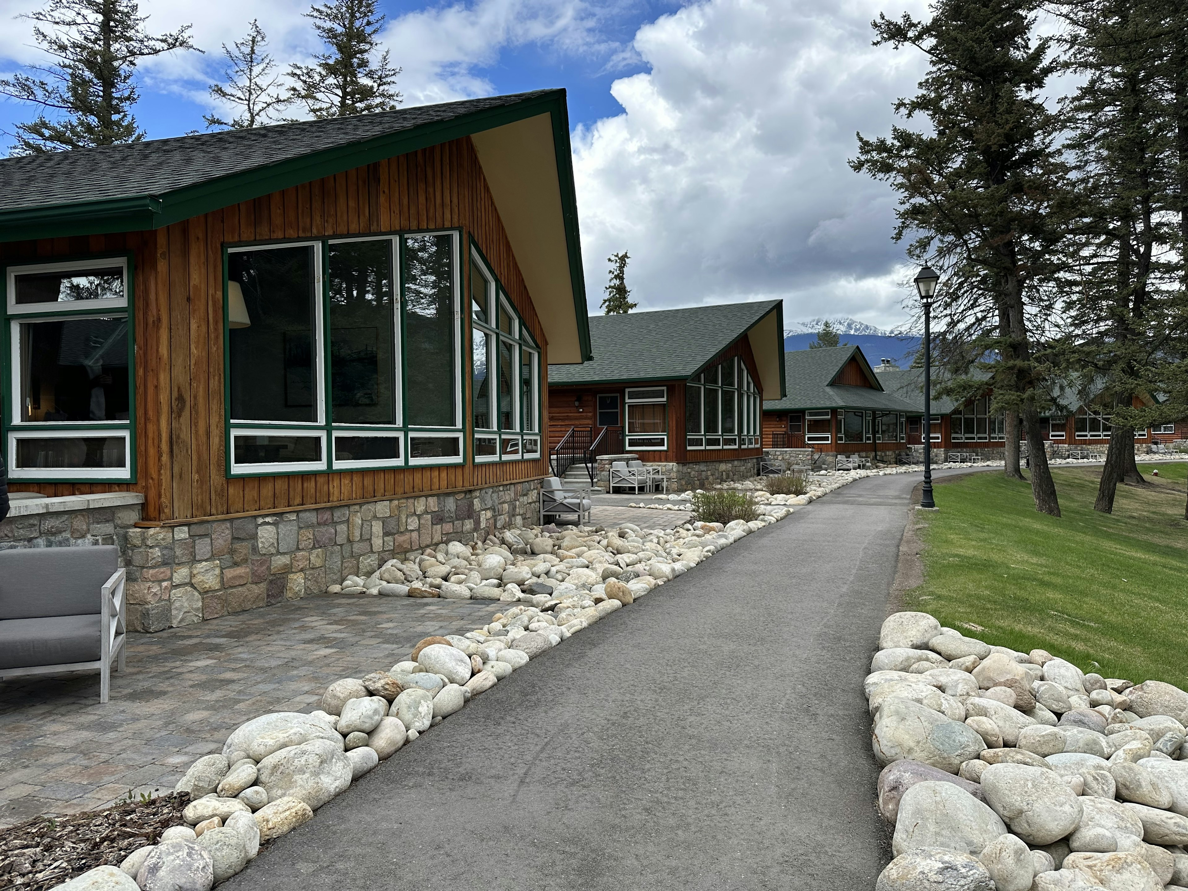 Wooden cabins with large windows along a pathway