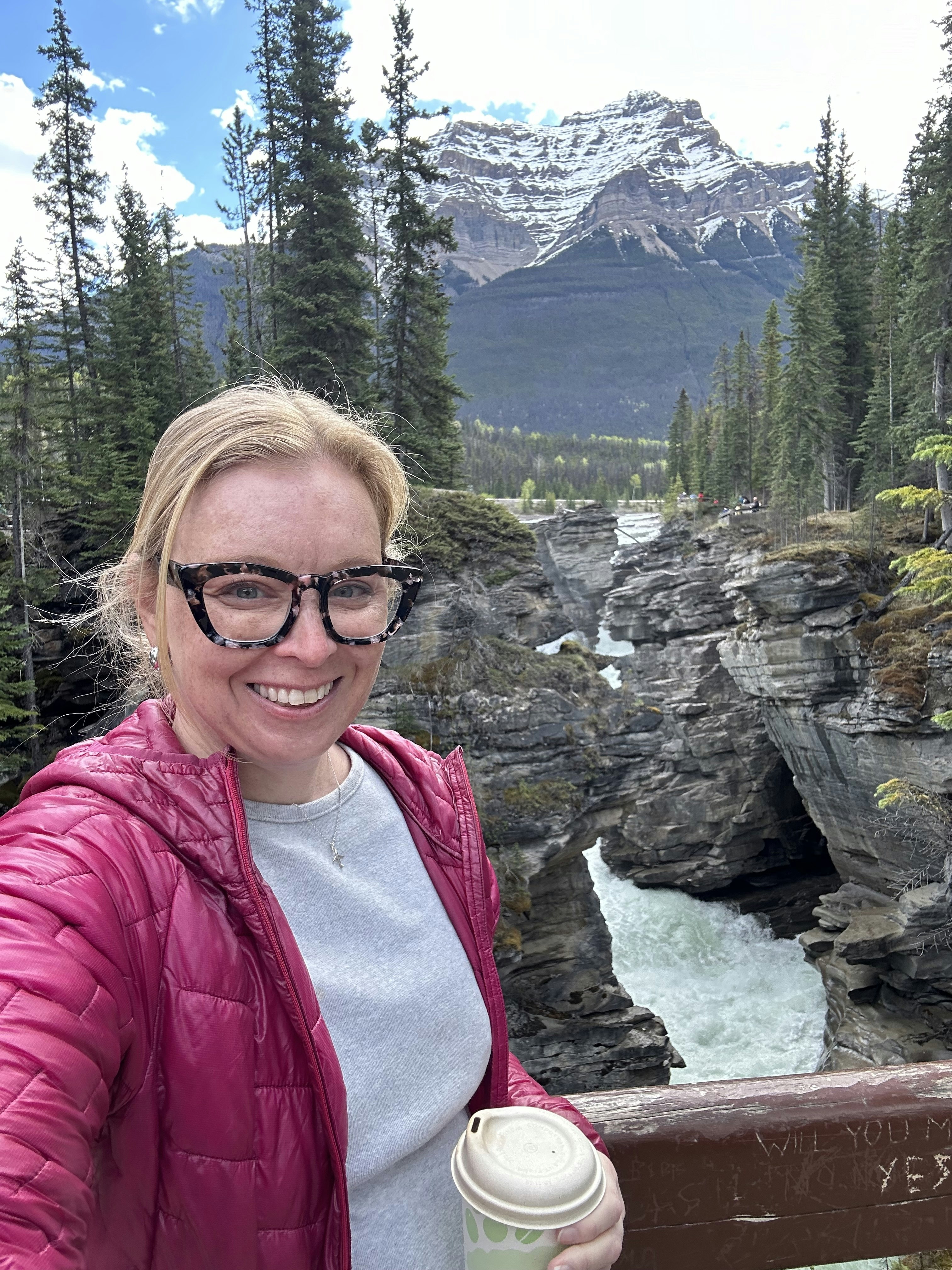 A woman with a waterfall behind her: Melissa Yeager at Athabasca Falls