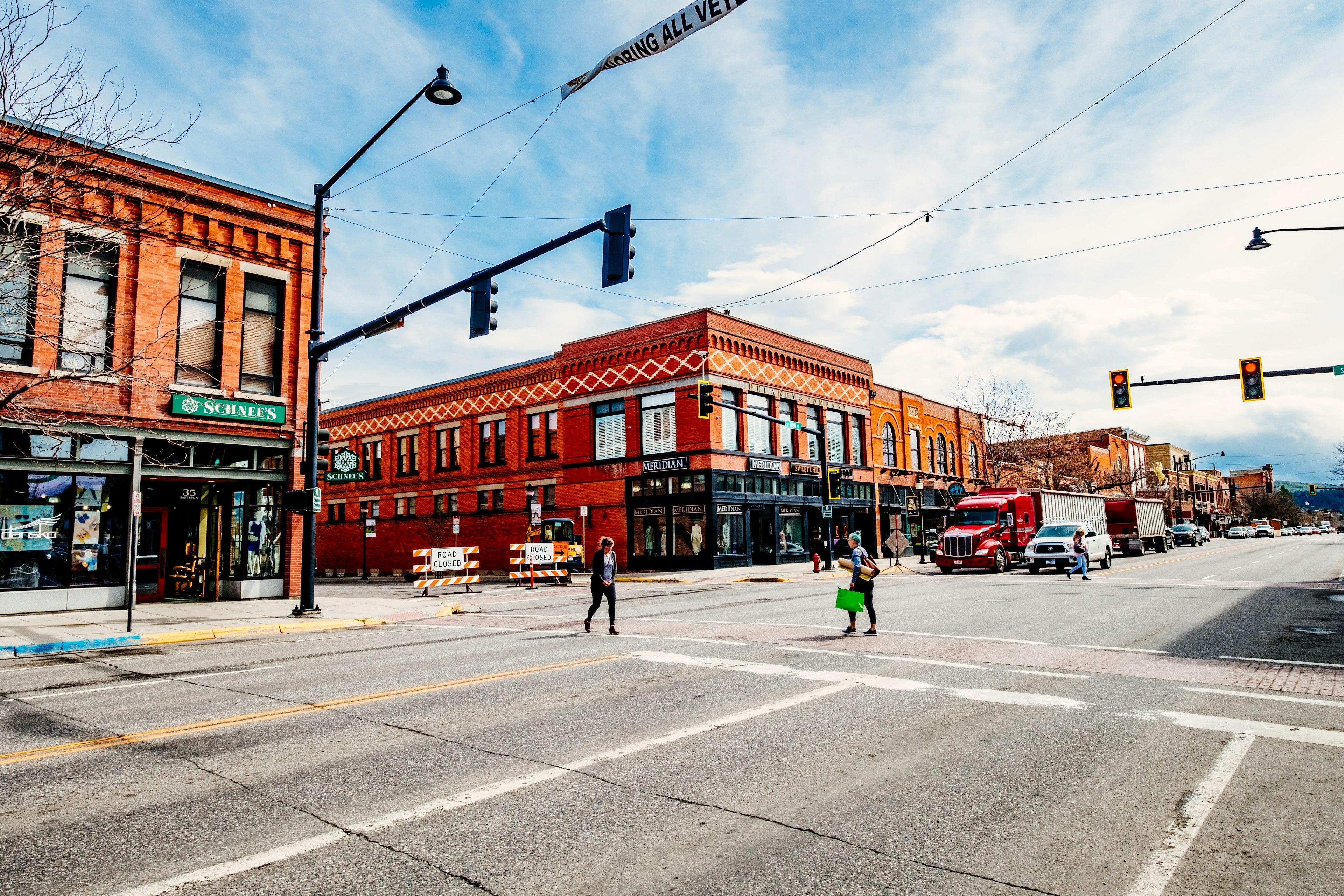 An intersection on a Main Street in a town with low-rise red-brick stores