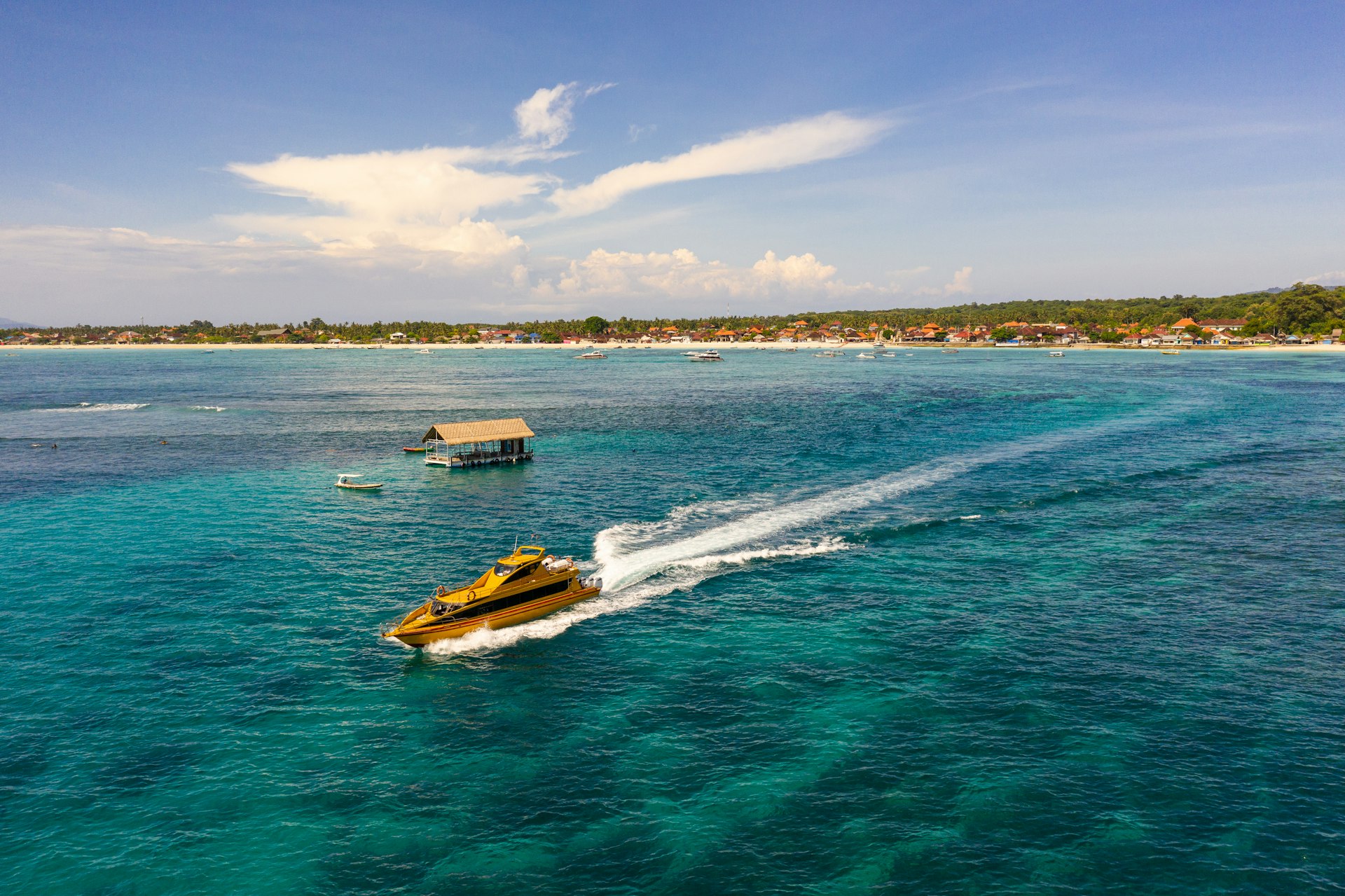 A fast-boat service leaves Nusa Lembongan in Bali, Indonesia, leaving a white trail in the water.