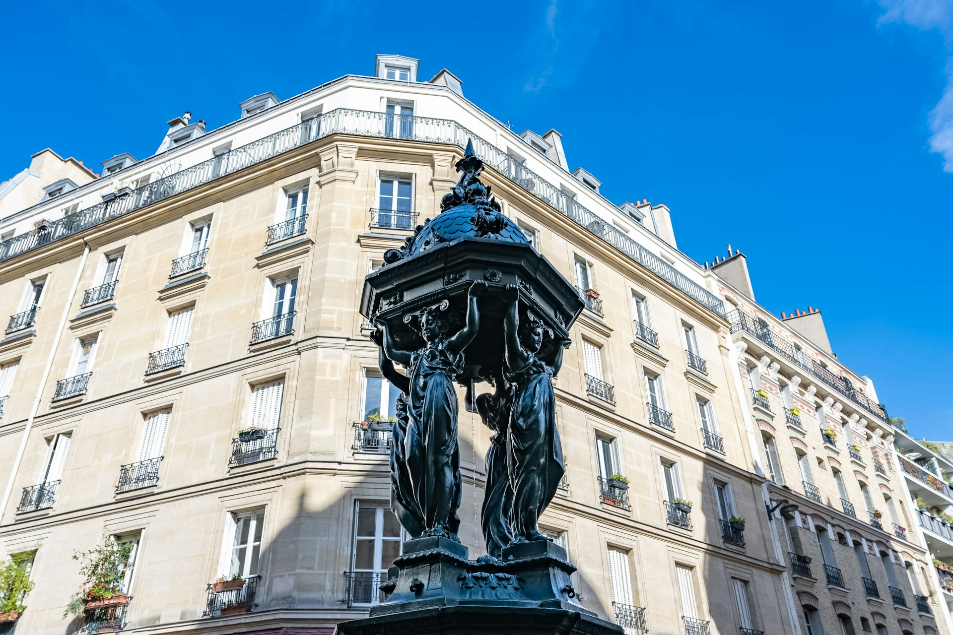 Paris, a green Wallace fountain, with typical building in background