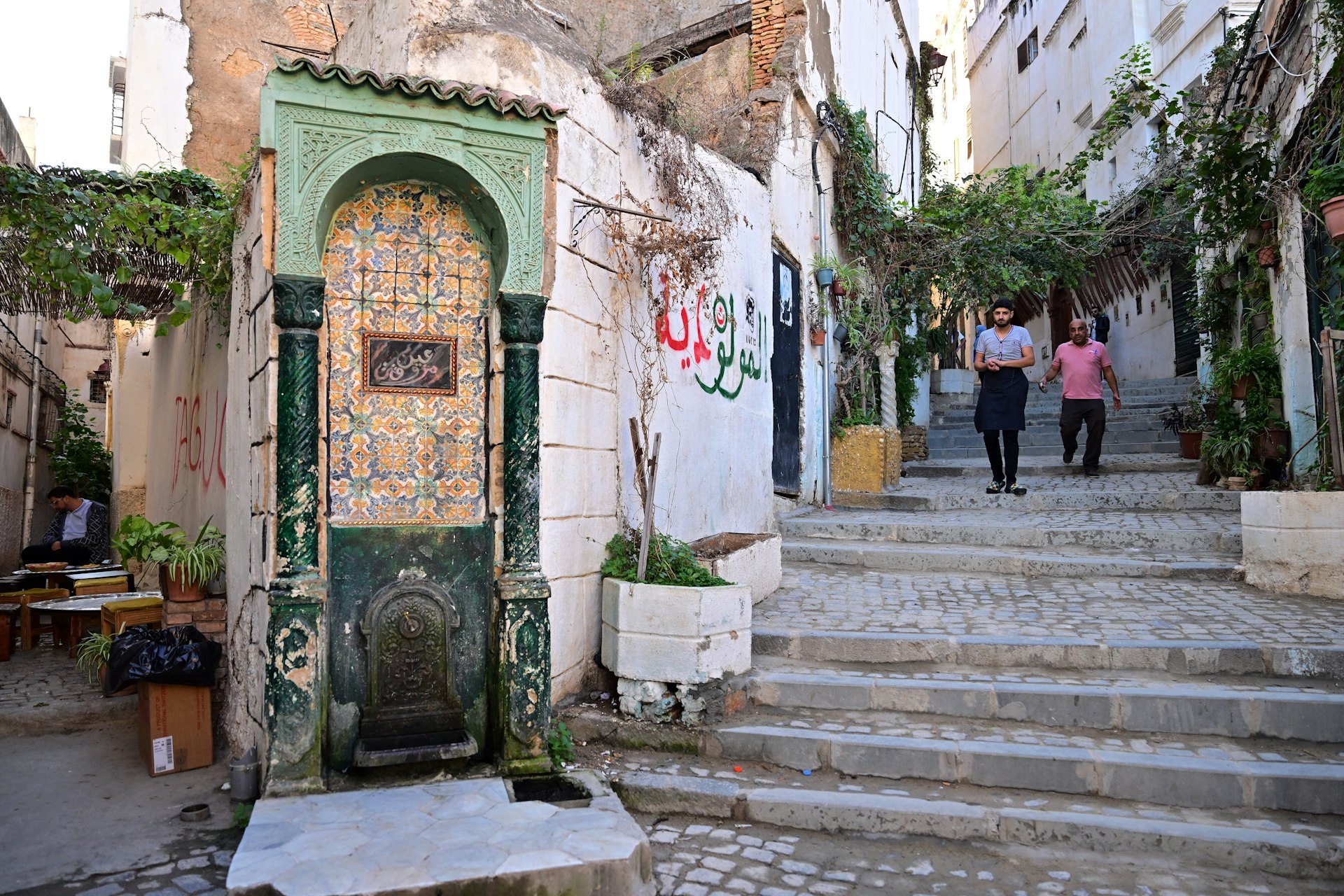 Men walk down a narrow alley in the historic Casbah of Algiers, Algeria