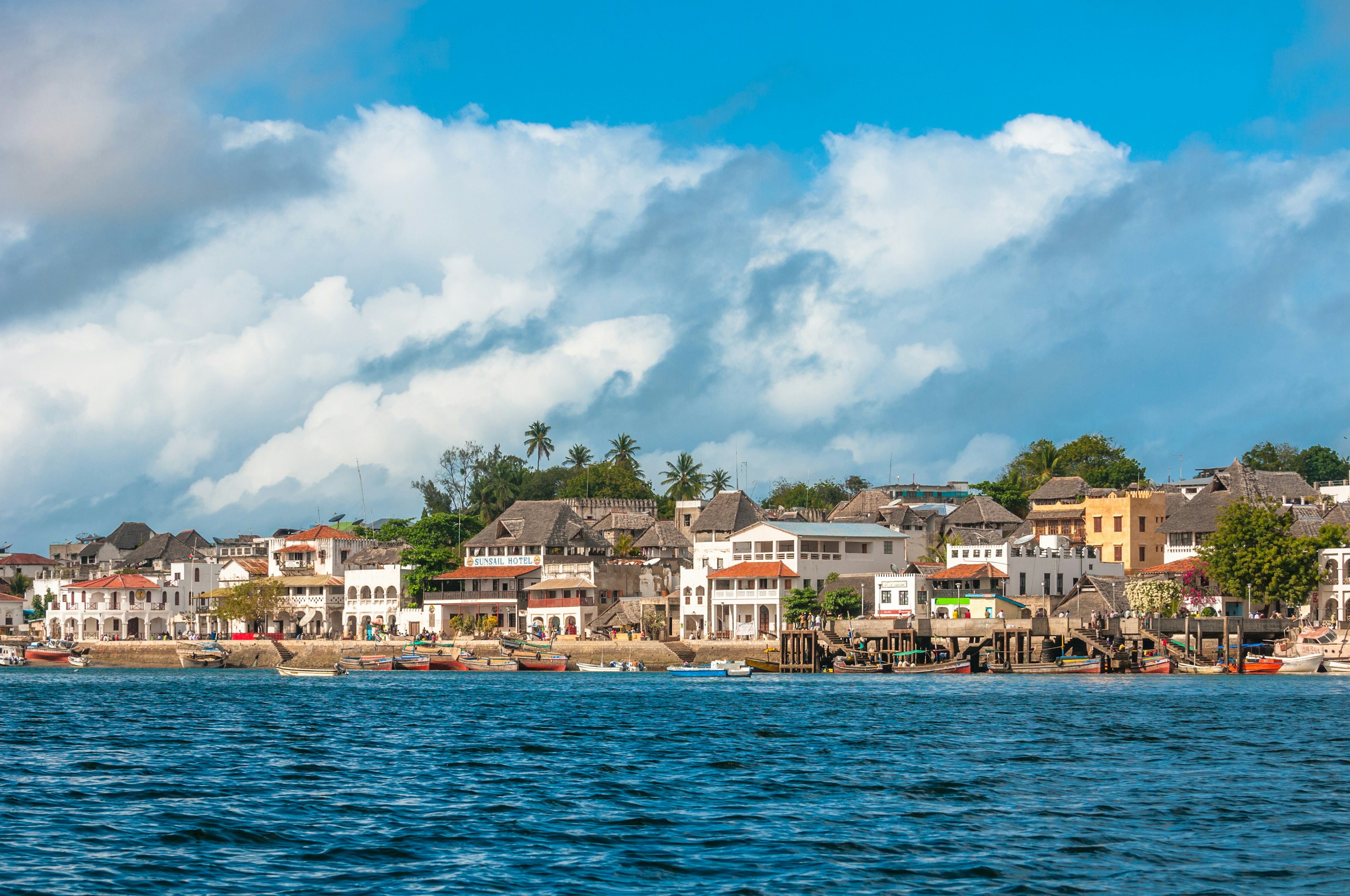 A historic row of buildings at the edge of a coastal town