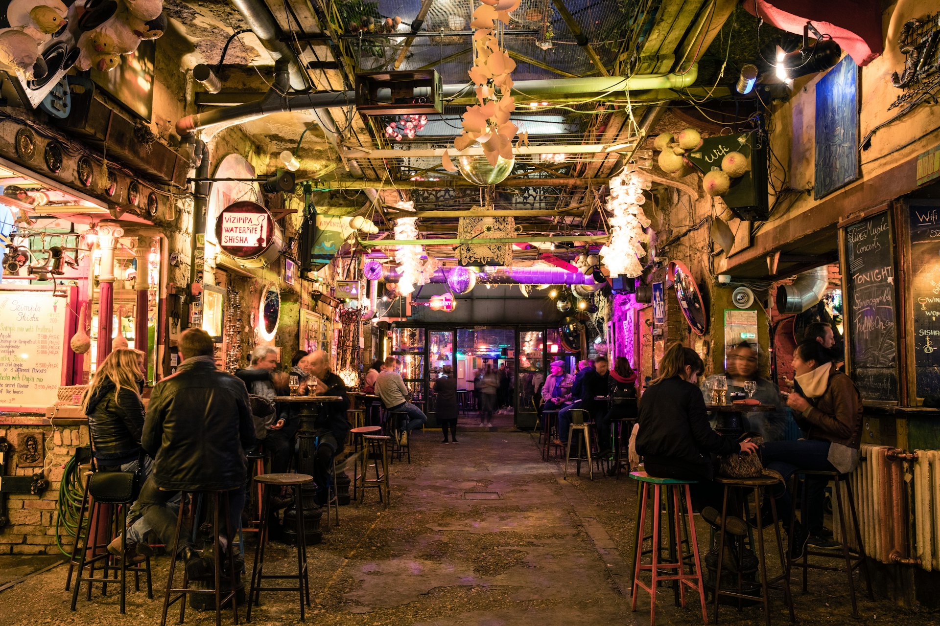 Many people sitting at tables in the ruin bar Szimpla Kert in Budapest, Hungary
