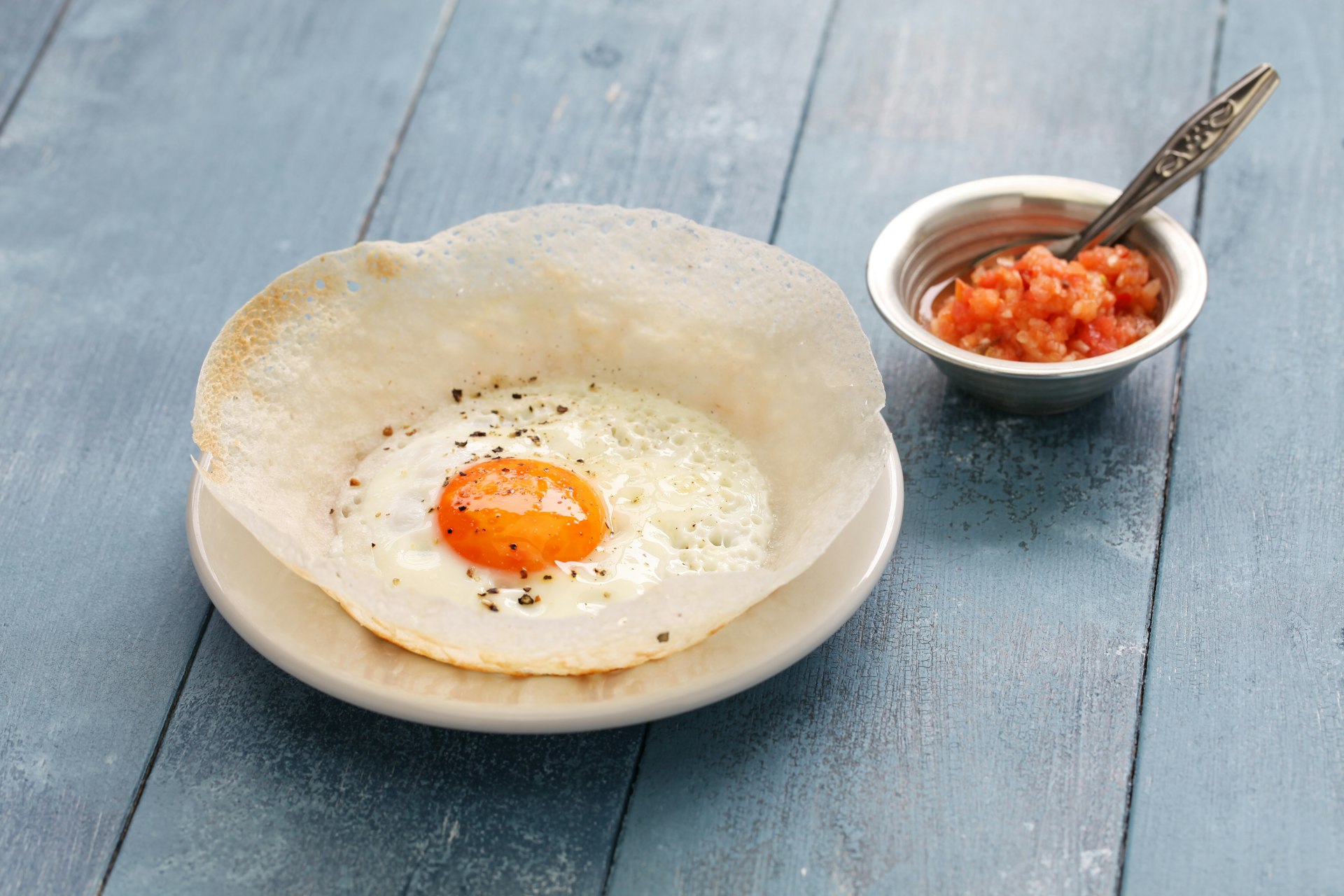 Sri Lankan egg hopper (bittara aappa) served on a plate.