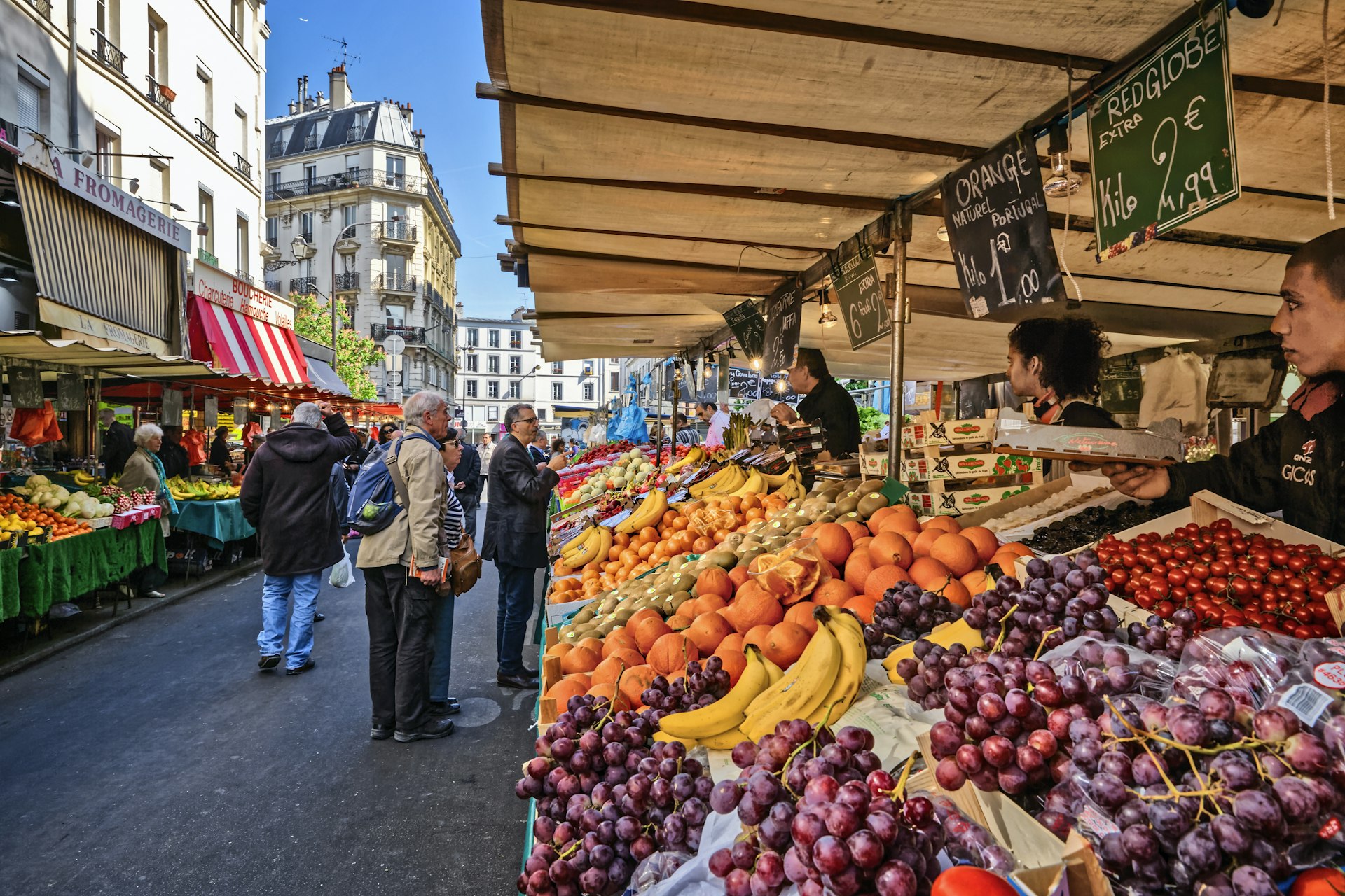 People shop for produce at an outdoor market in France