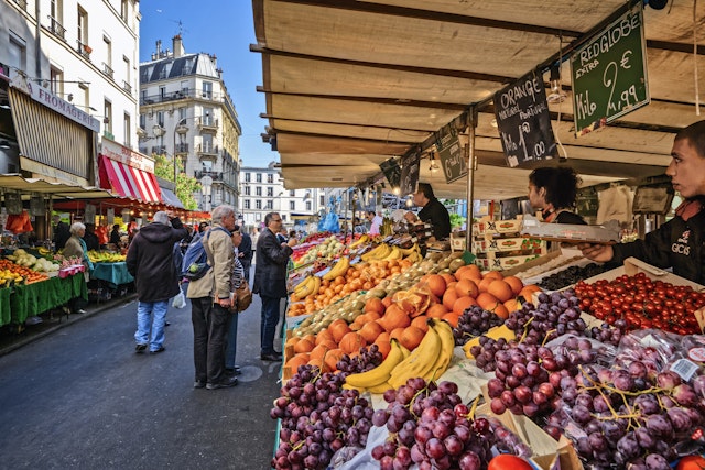 People shop for produce at an outdoor market in France