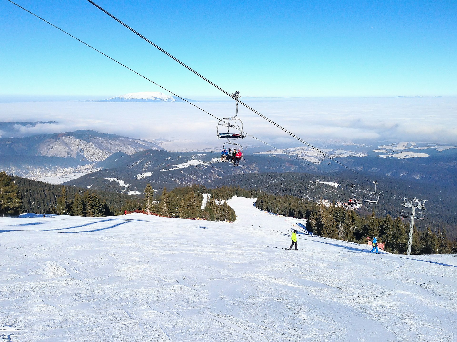 Skiiers on a chairlift overlooking the slopes in Bulgaria