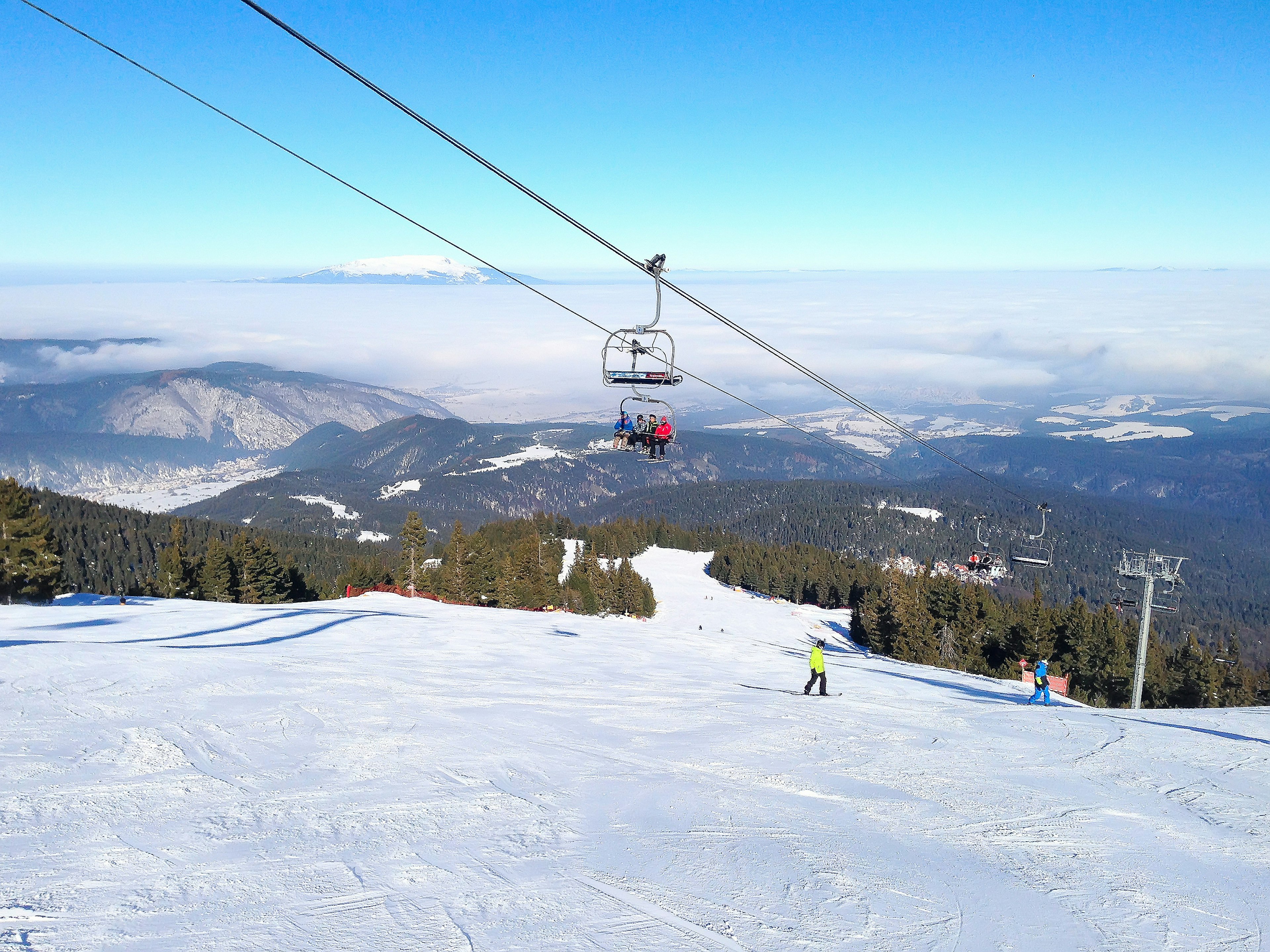 Skiiers on a chairlift overlooking the slopes in Bulgaria