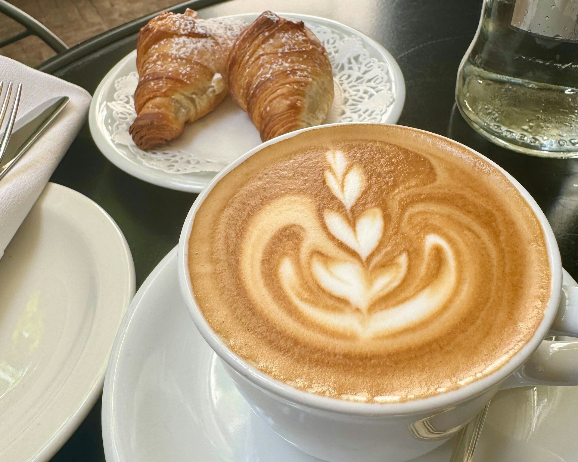 Cappuccino and a cornetto pastry close up