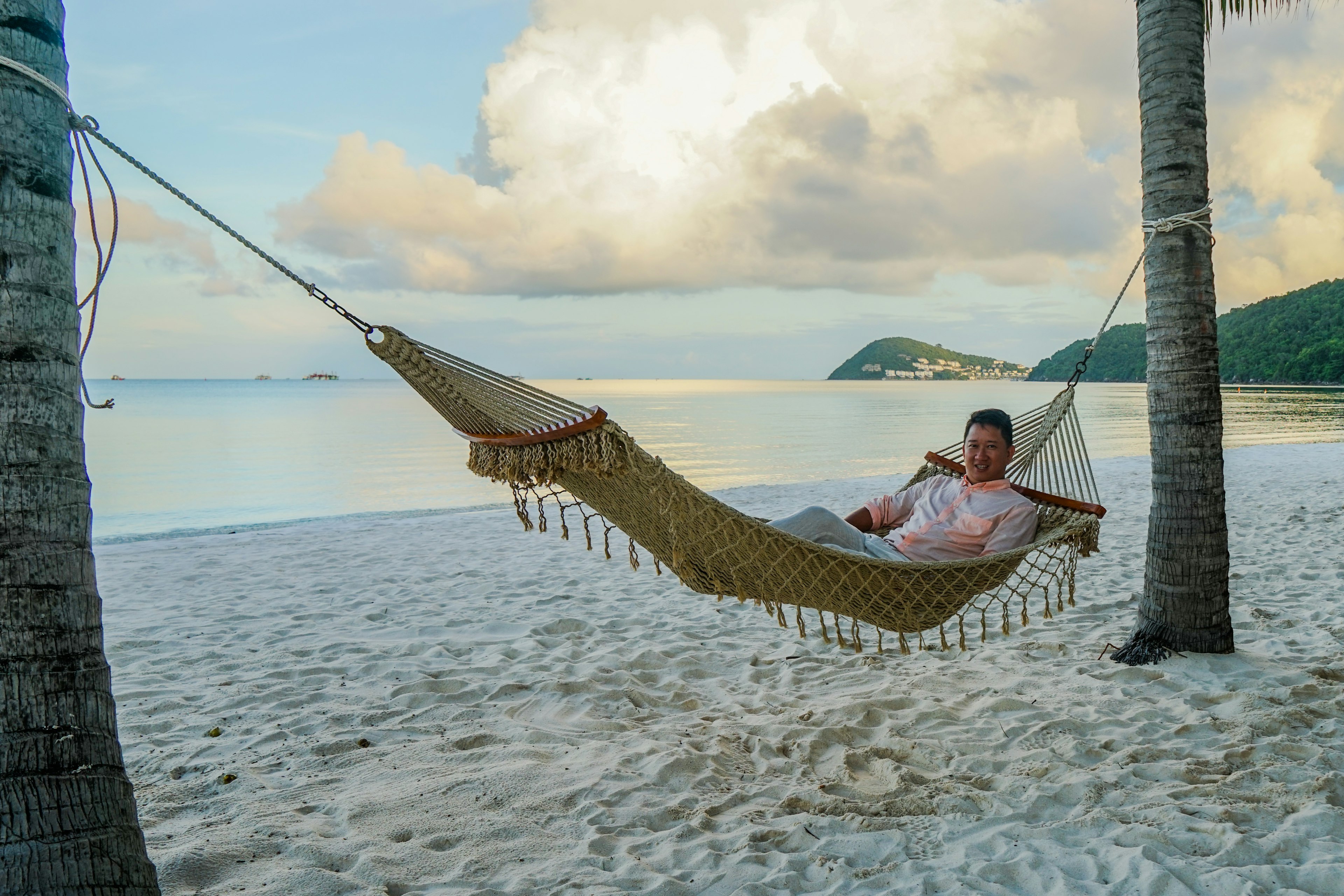 Lonely Planet destination editor James Pham is lying on a hammock between two palm trees on Kem Beach, Phu Quoc, Vietnam