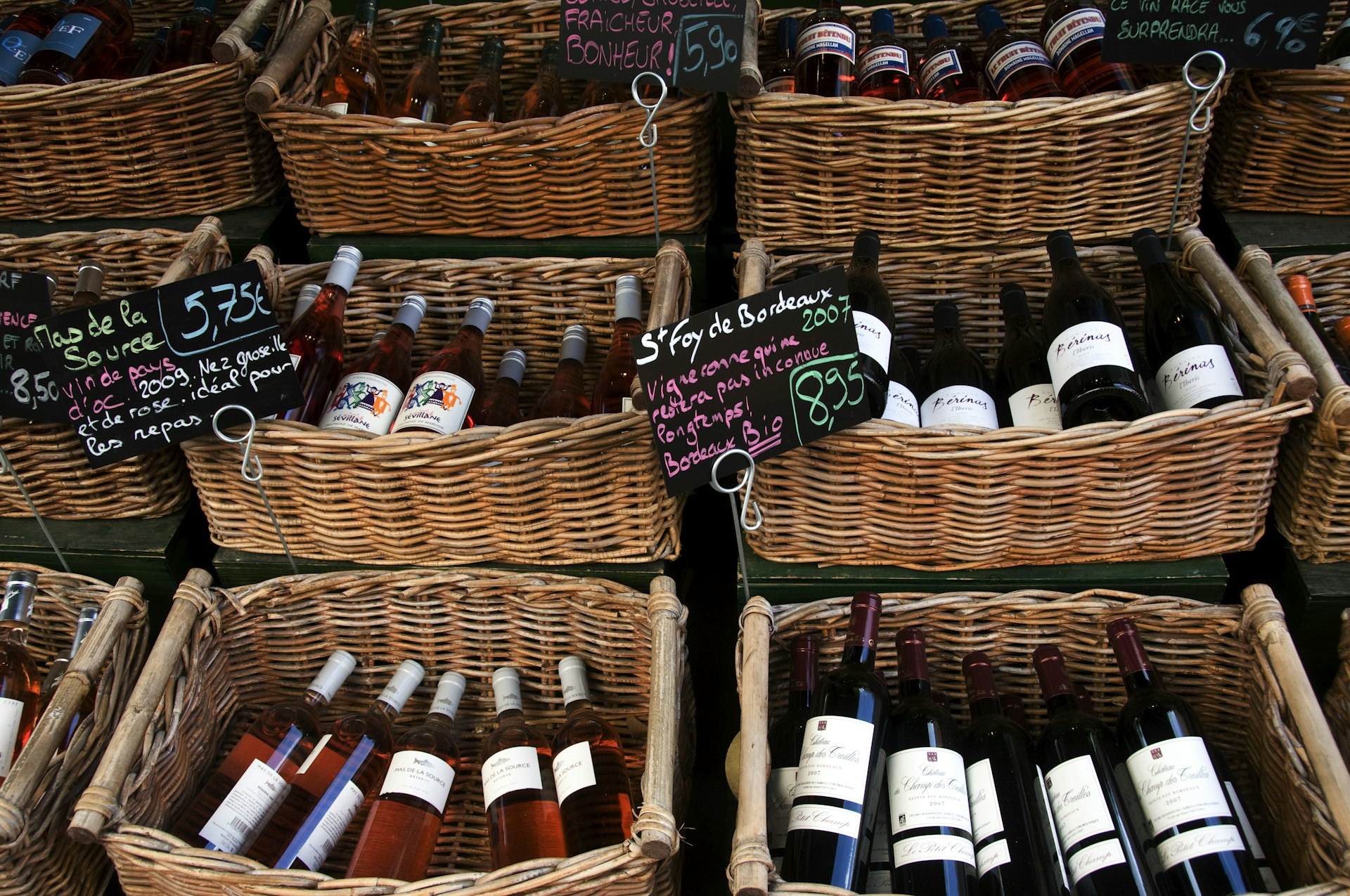 Overhead photo of wine bottles in baskets at a wine shop in France