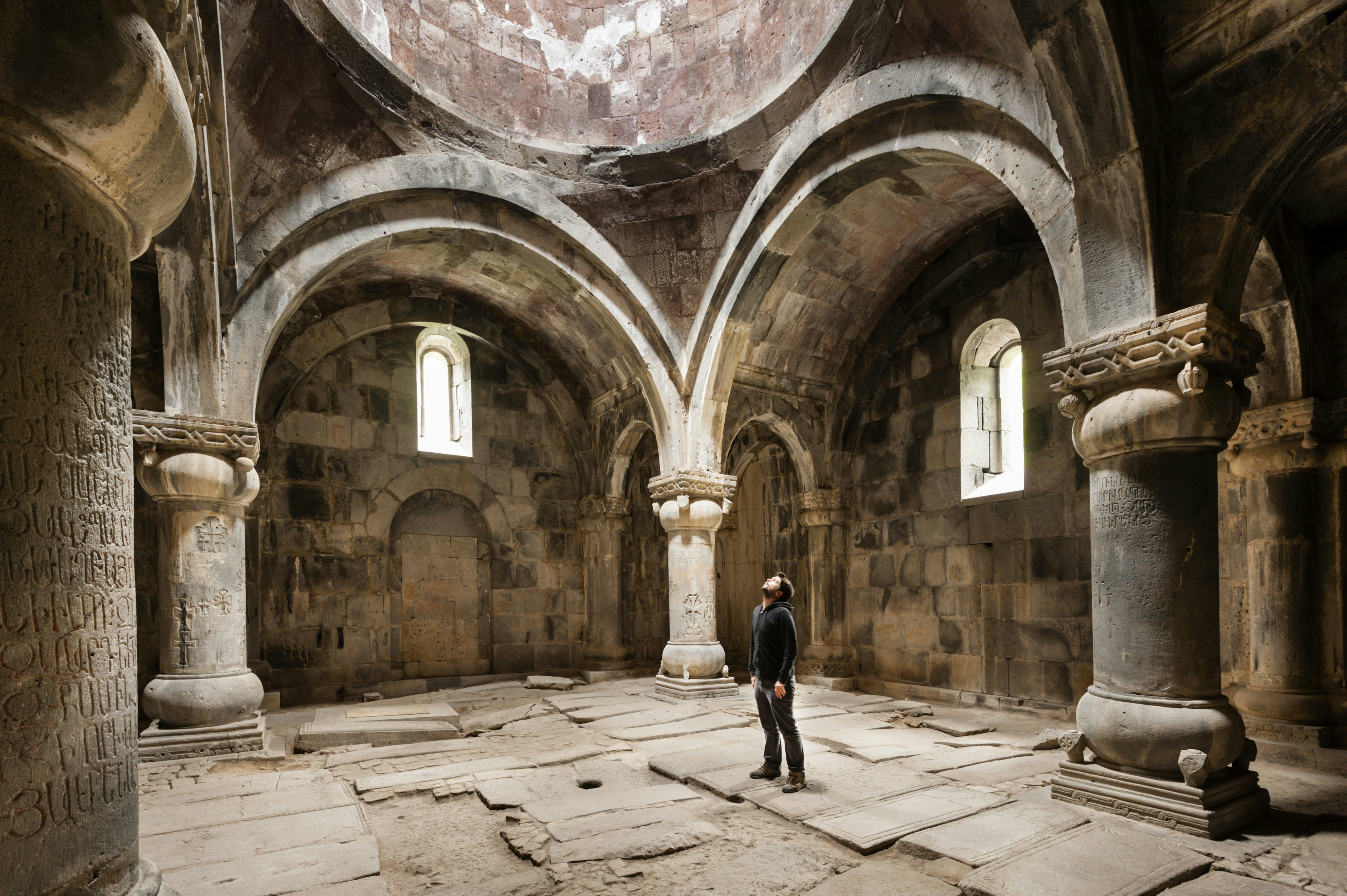 A man looks up at a vaulted ceiling at Sanahin Monastery, Armenia